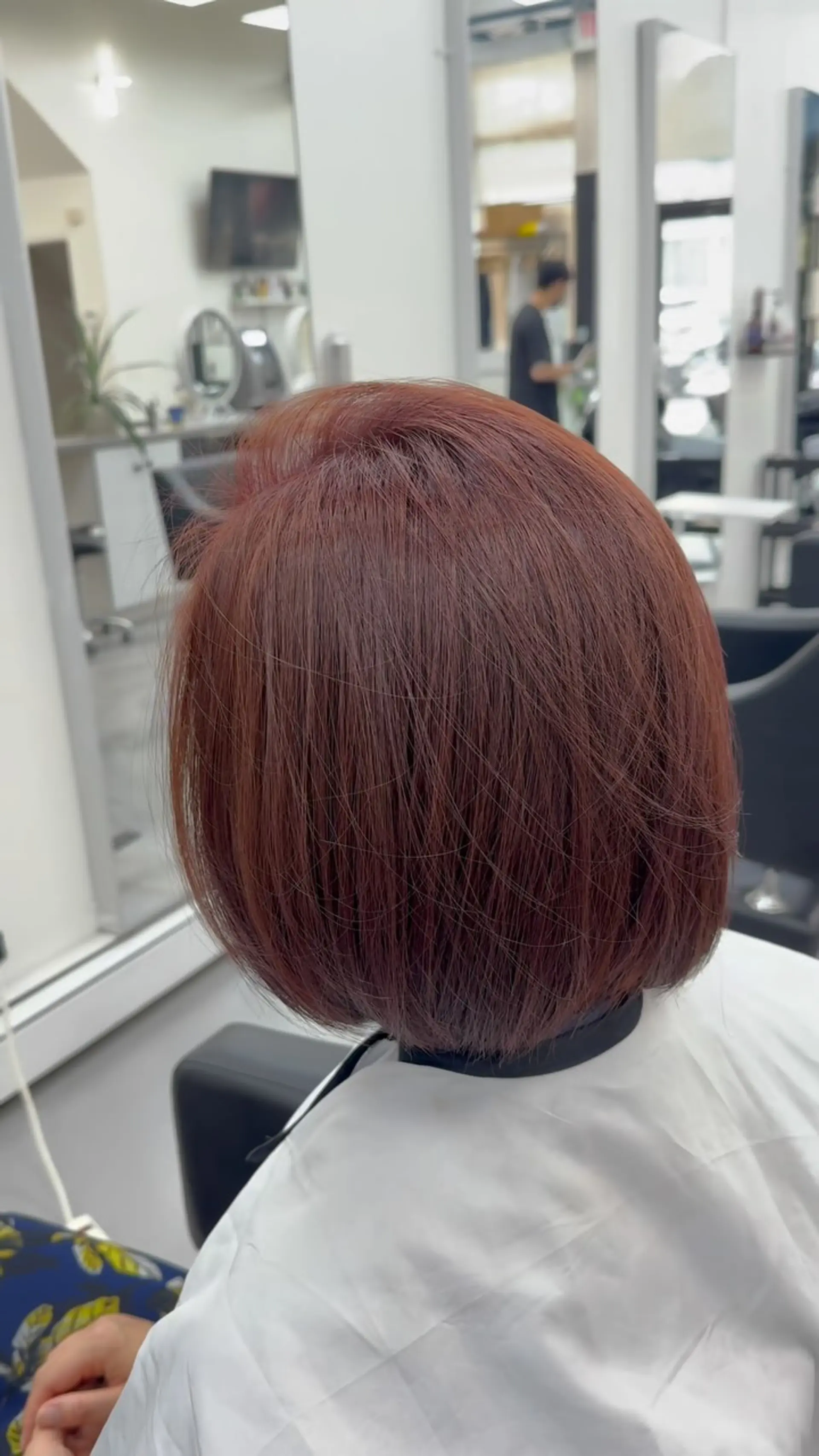 A sleek, rounded short bob cut featuring a rich, warm auburn-copper tone with smooth texture. 1