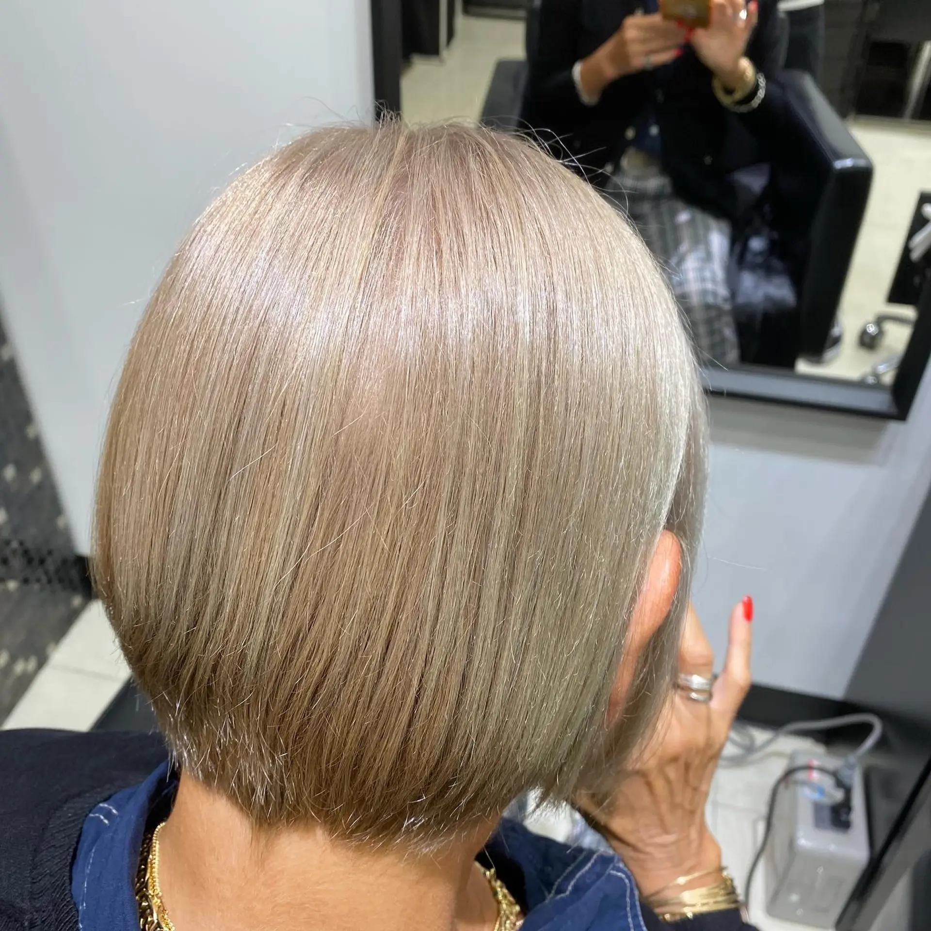 A stylish short bob with textured ends, colored in a unique silver blonde shade. 1