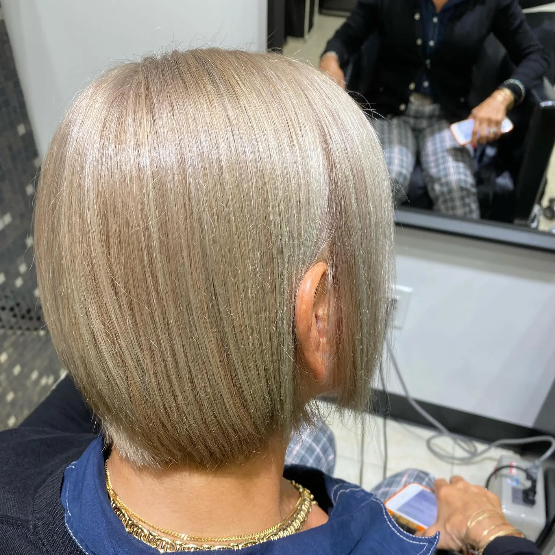 A stylish short bob with textured ends, colored in a unique silver blonde shade. 2