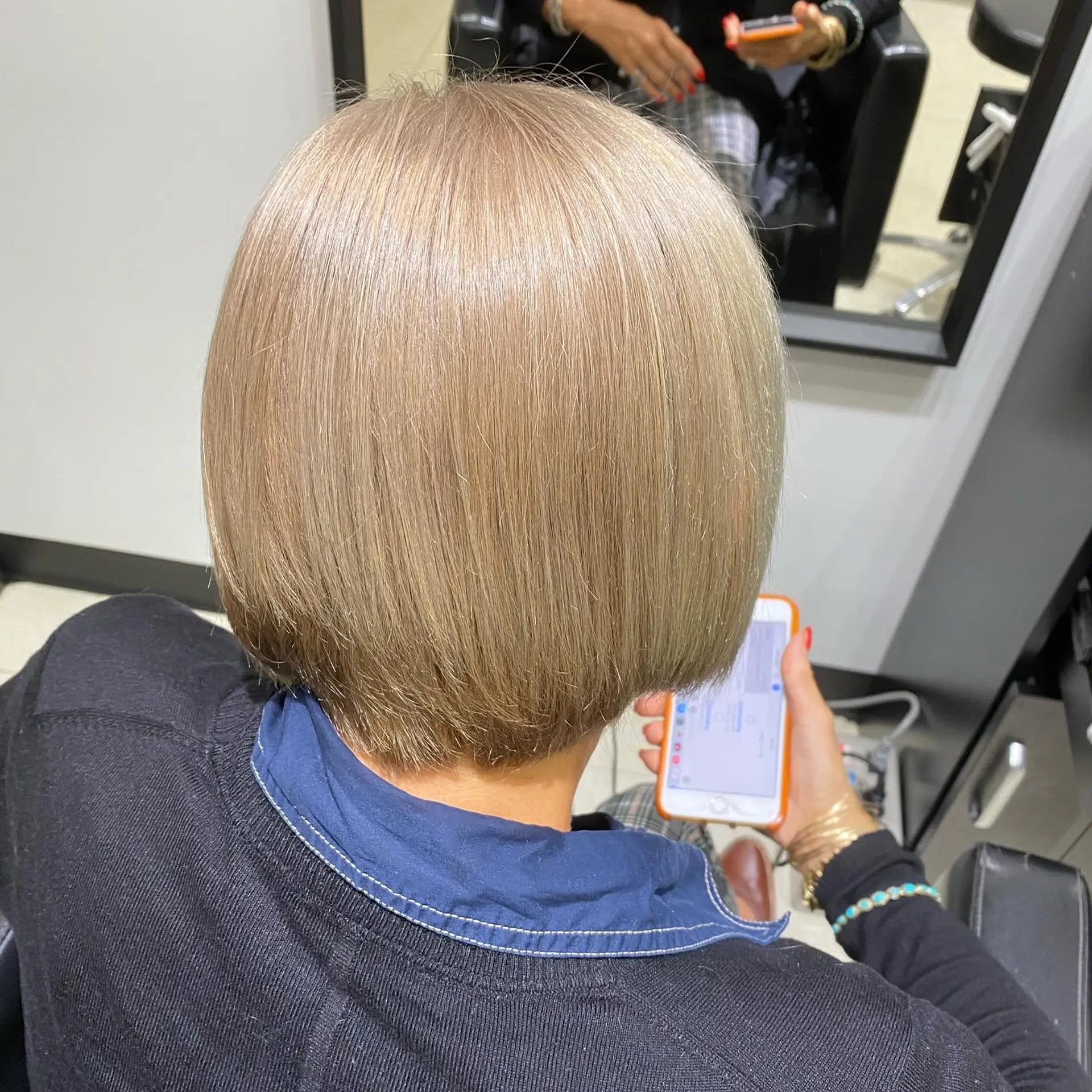 A stylish short bob with textured ends, colored in a unique silver blonde shade. 3