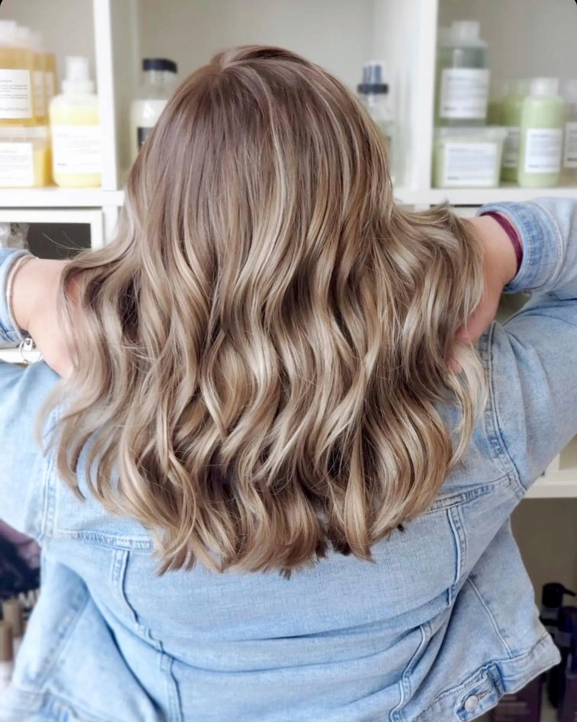Medium-length textured waves featuring a natural root melt into dimensional creamy blonde tones. 1
