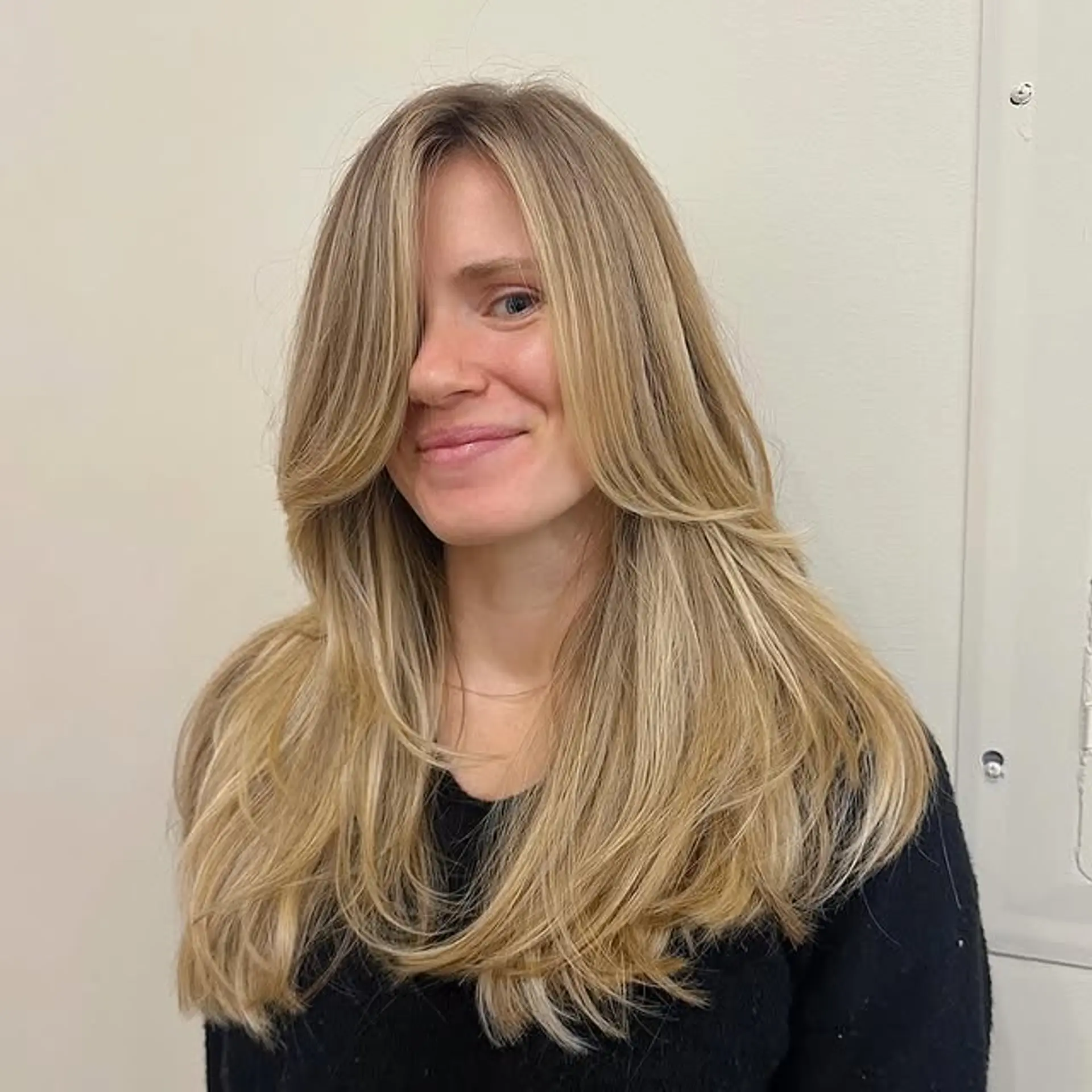 A long, layered hairstyle with face-framing curtain bangs. 1