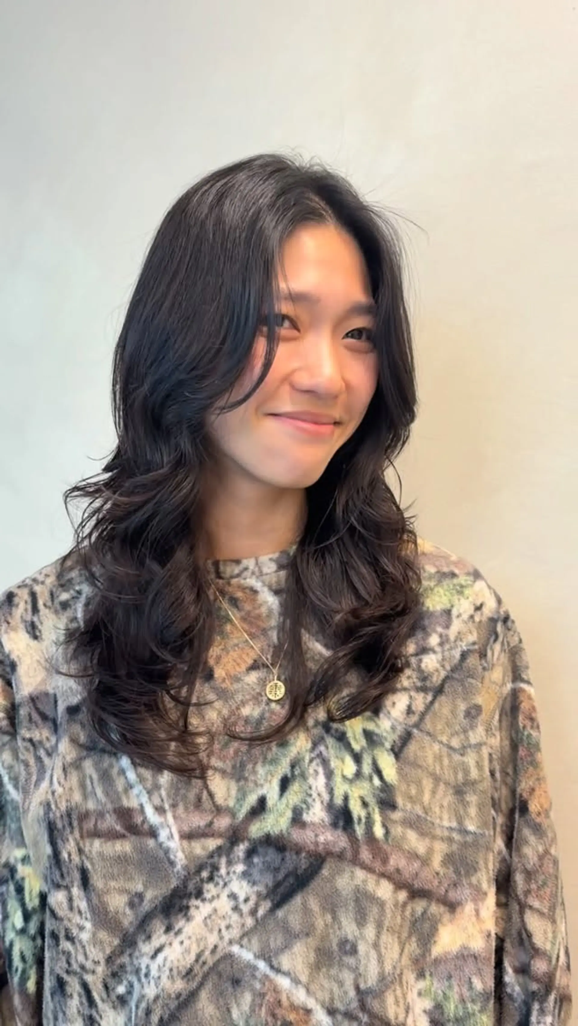 Long dark layered hair styled with soft, natural digital perm waves and face-framing curtain layers. 1