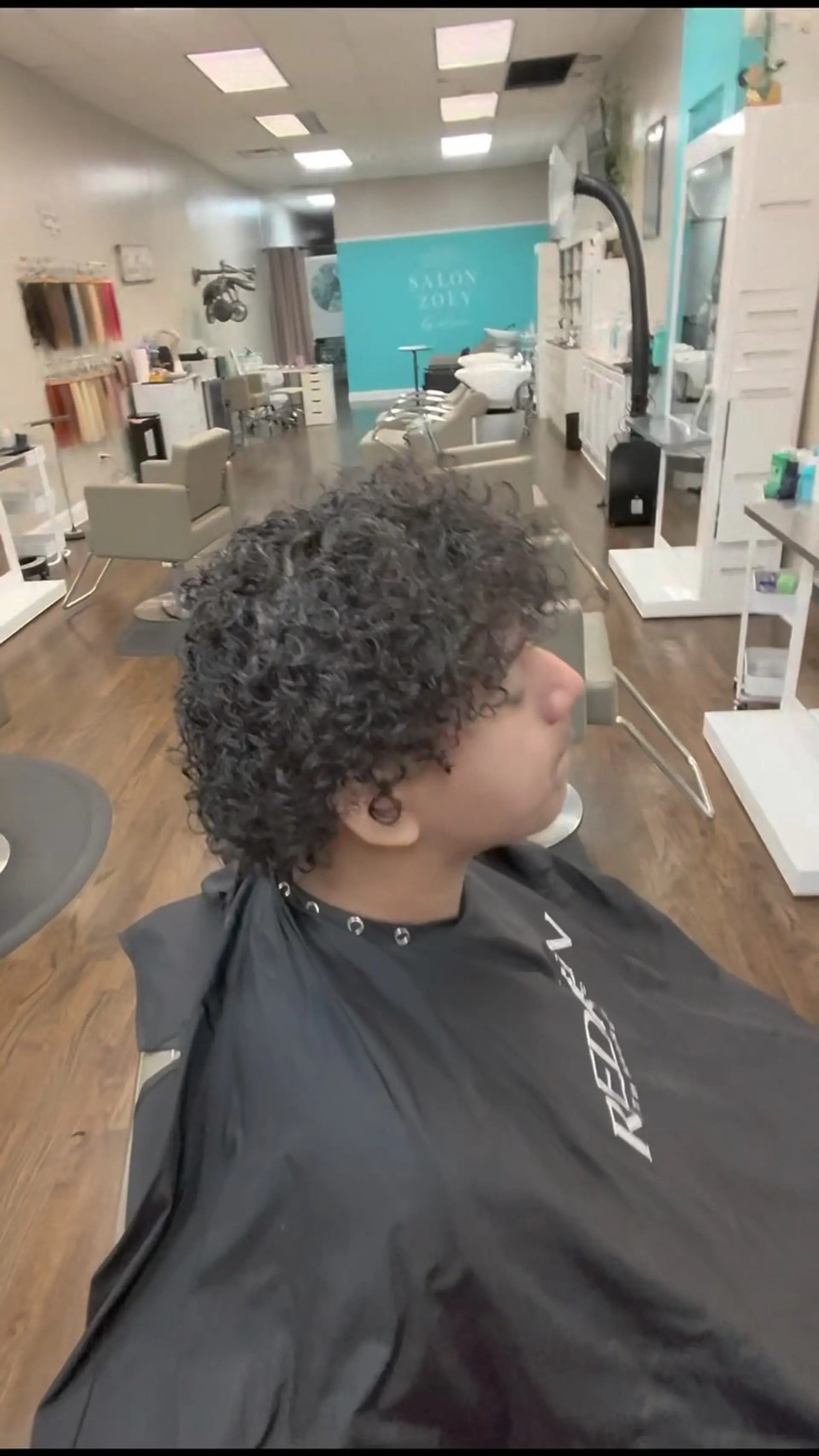 Defined, textured short curls cut into a rounded shape with curls falling forward across the forehead. 1