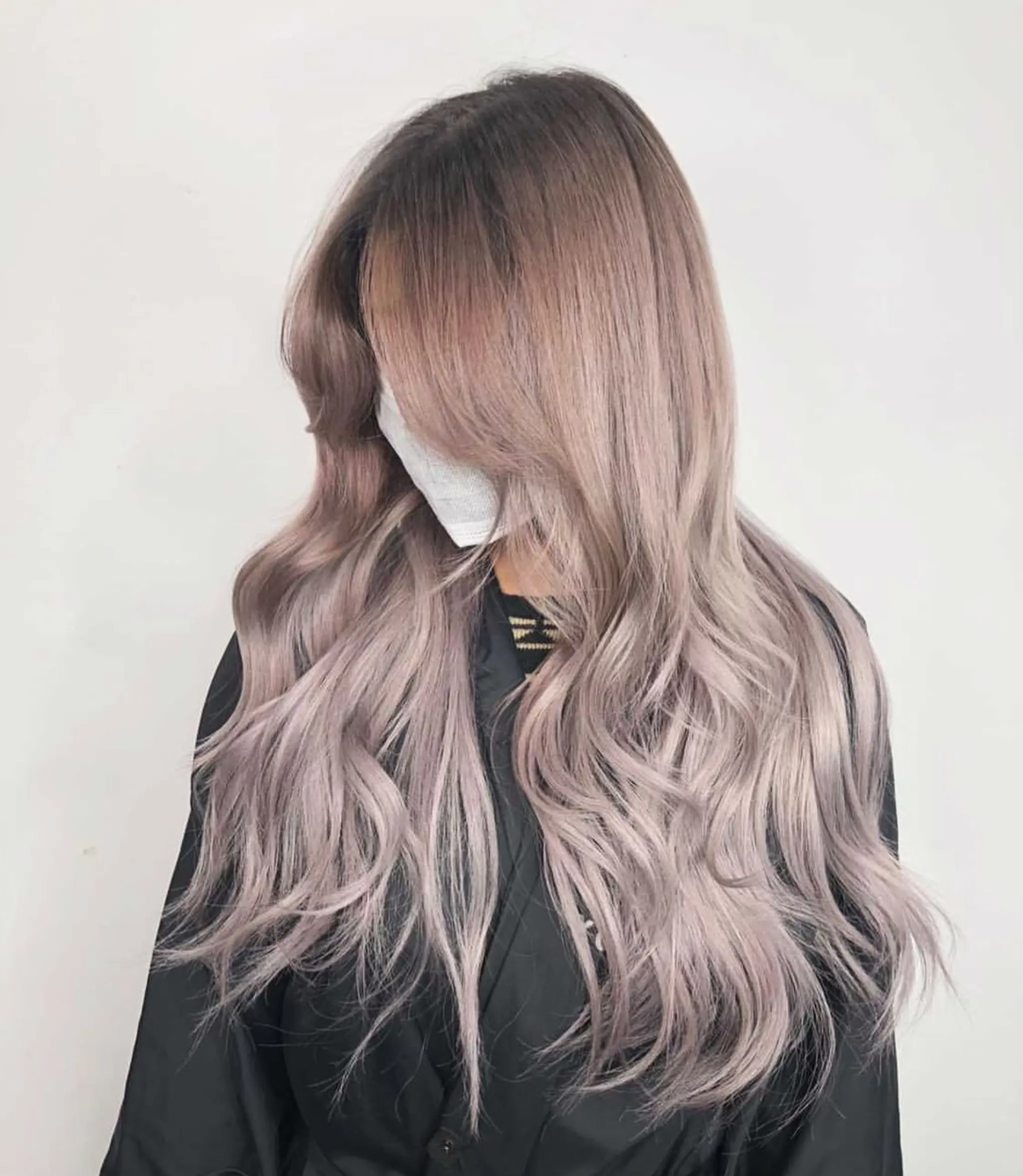 Long, wavy hair with a blend of platinum blonde and muted lavender, featuring face-framing layers and a soft gradient color.
Stylist - @xcellent_jason