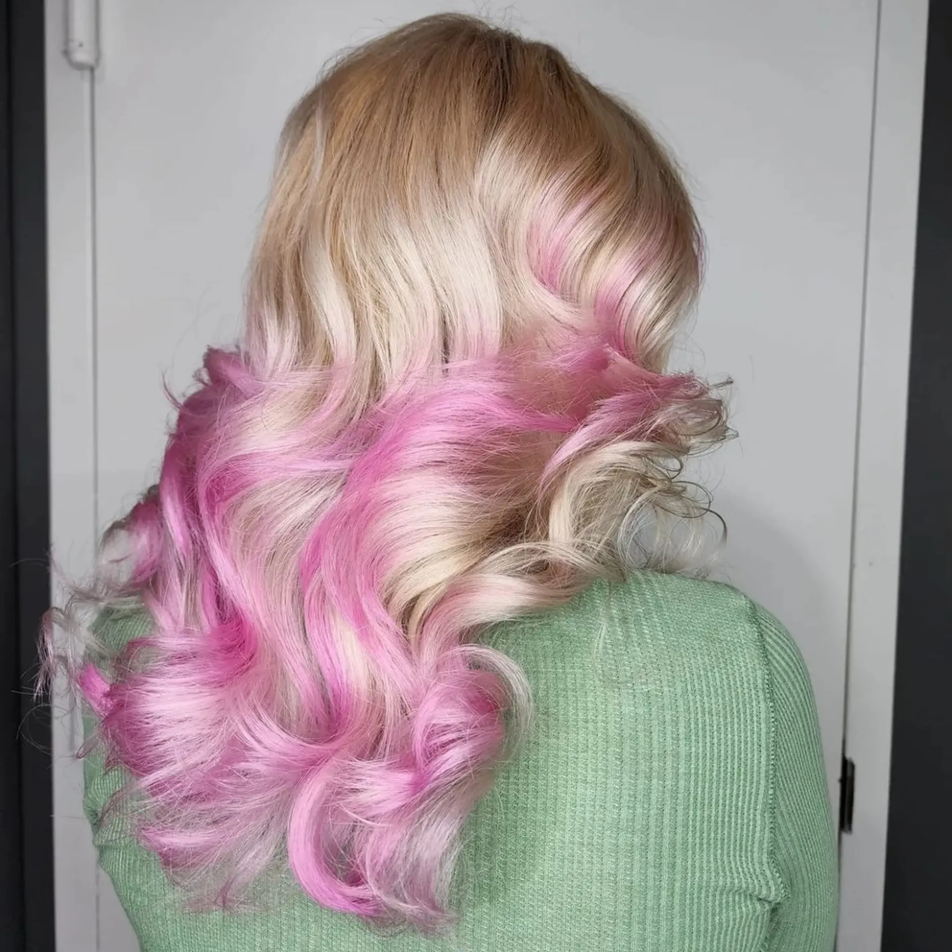 Long, wavy hair with an ombre effect transitioning from luminous blonde to pastel pink, featuring soft waves. 1