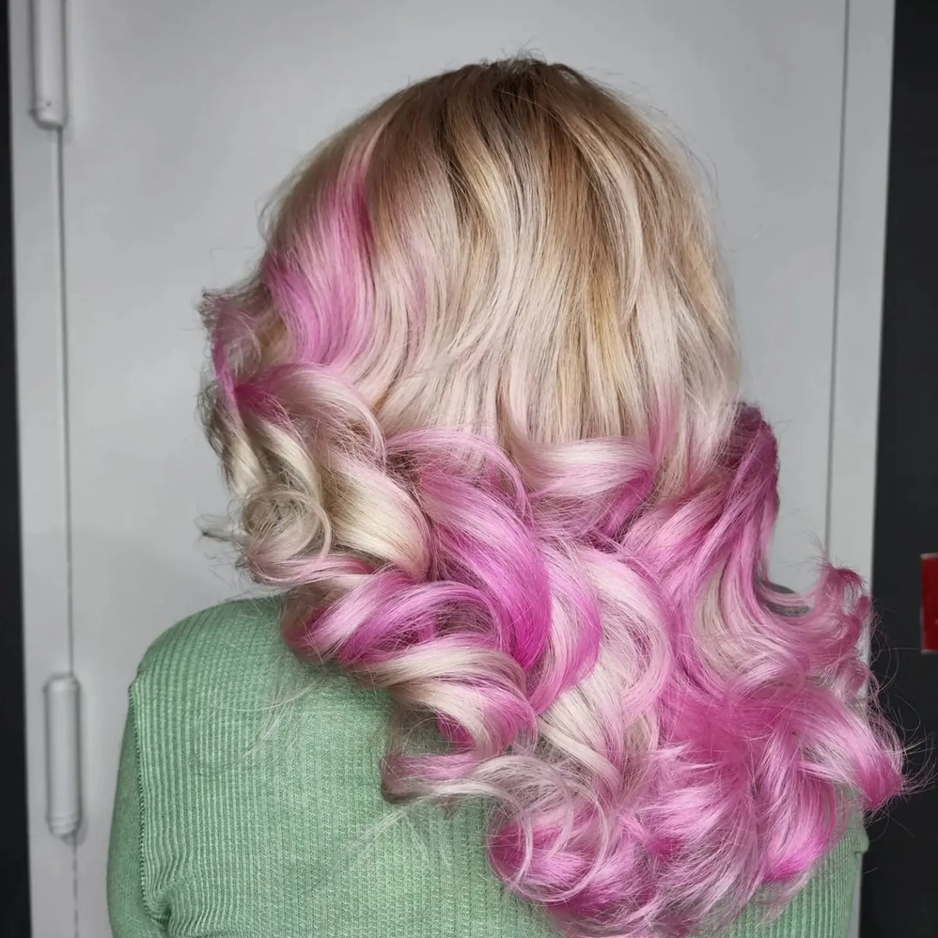 Long, wavy hair with an ombre effect transitioning from luminous blonde to pastel pink, featuring soft waves. 2