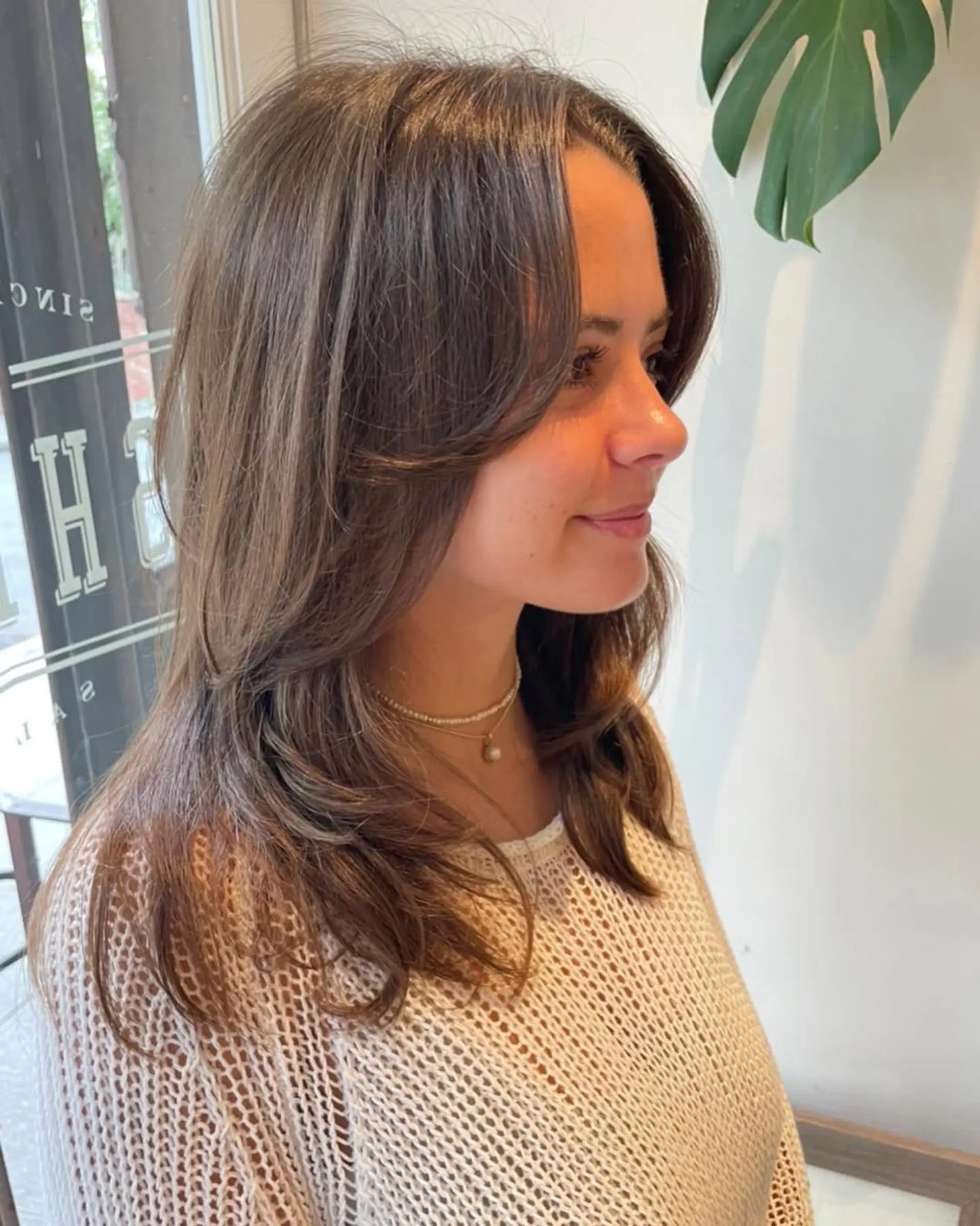 A medium-length layered haircut with curtain bangs. 1