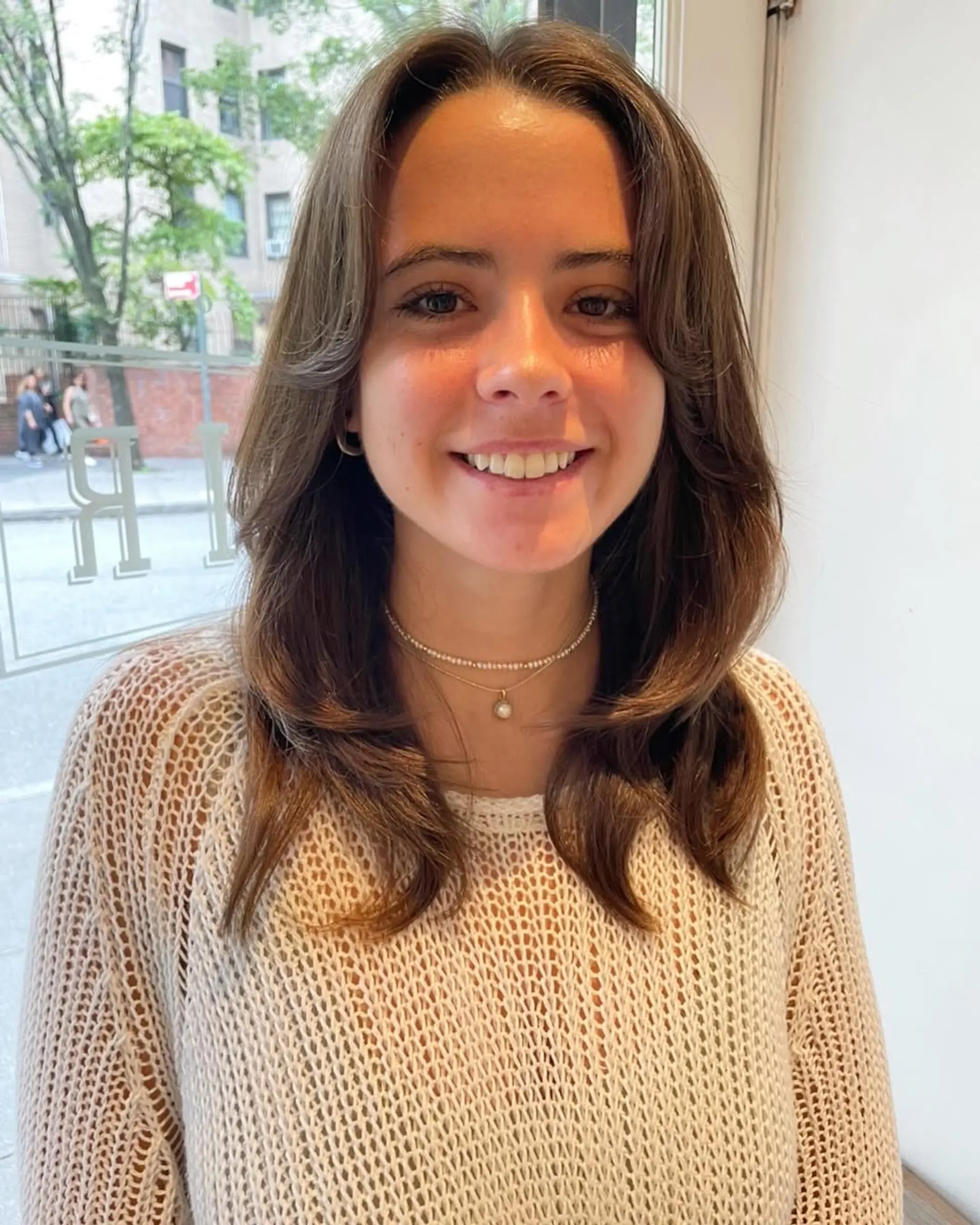 A medium-length layered haircut with curtain bangs. 2