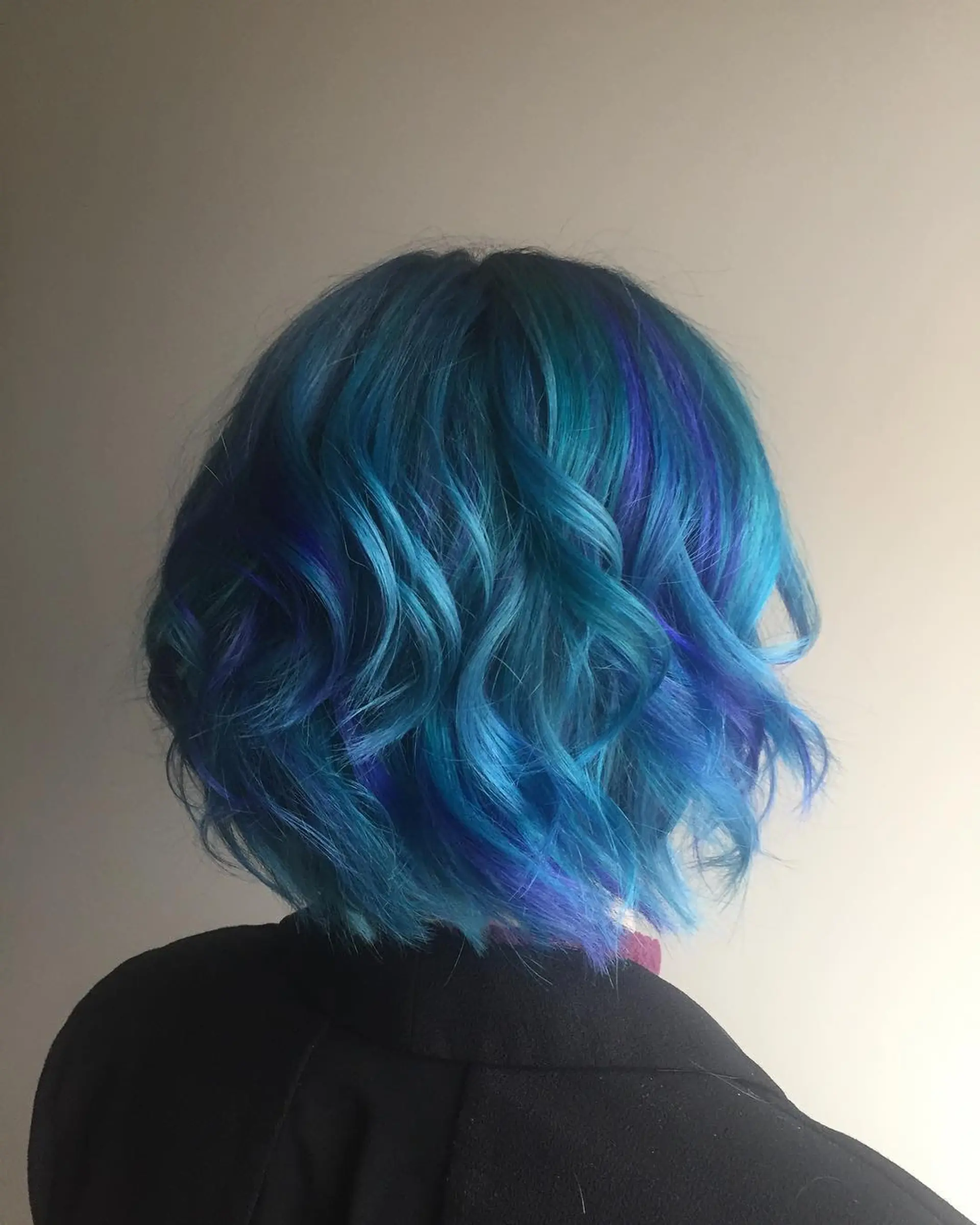 Wavy bob with a vibrant mix of blues and teal highlights, complemented by subtle purple accents. 1