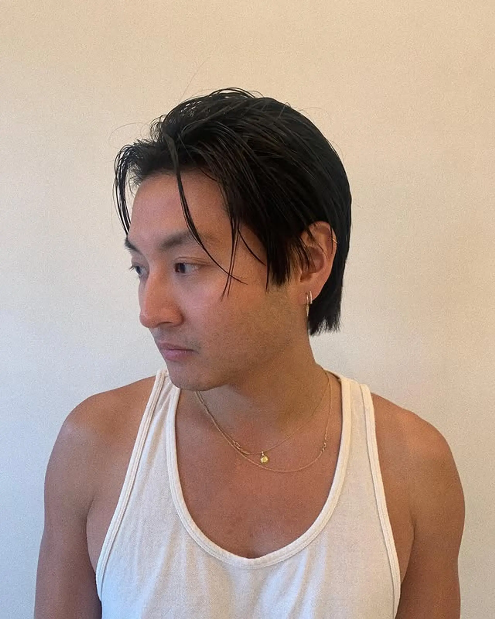 A slicked-back medium-length hairstyle with tapered sides for a professional look. 1