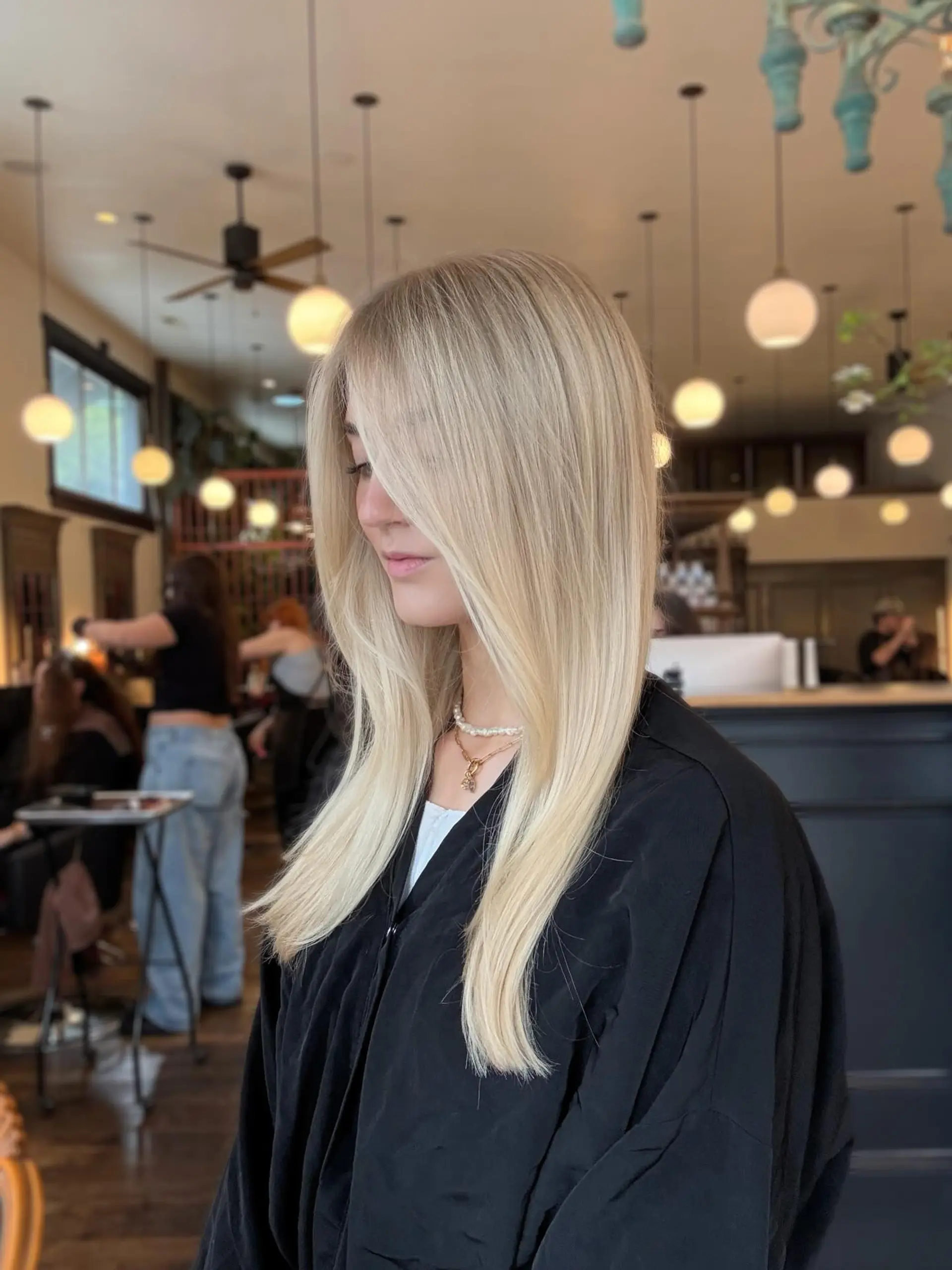 Sleek and straight long blonde hair styled with face-framing layers and a smooth, silky finish. 1