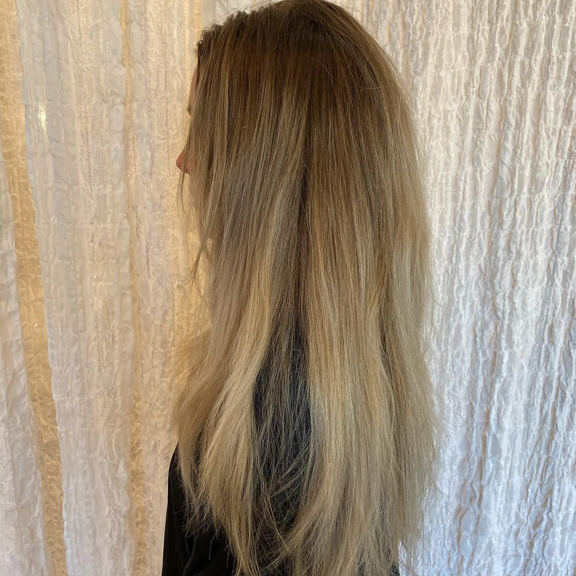 Long straight hair featuring a lived-in cool ash blonde balayage transitioning seamlessly from natural light brown roots to icy blonde ends. 1