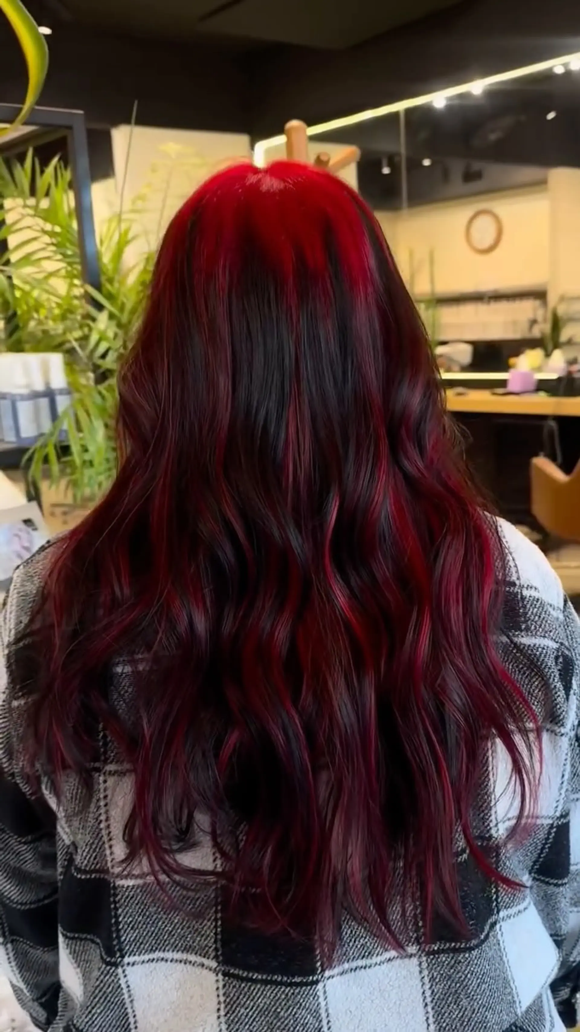 Long, gently tousled wavy hair featuring vibrant crimson red ghost roots blended over a dark base with red ribbons. 1