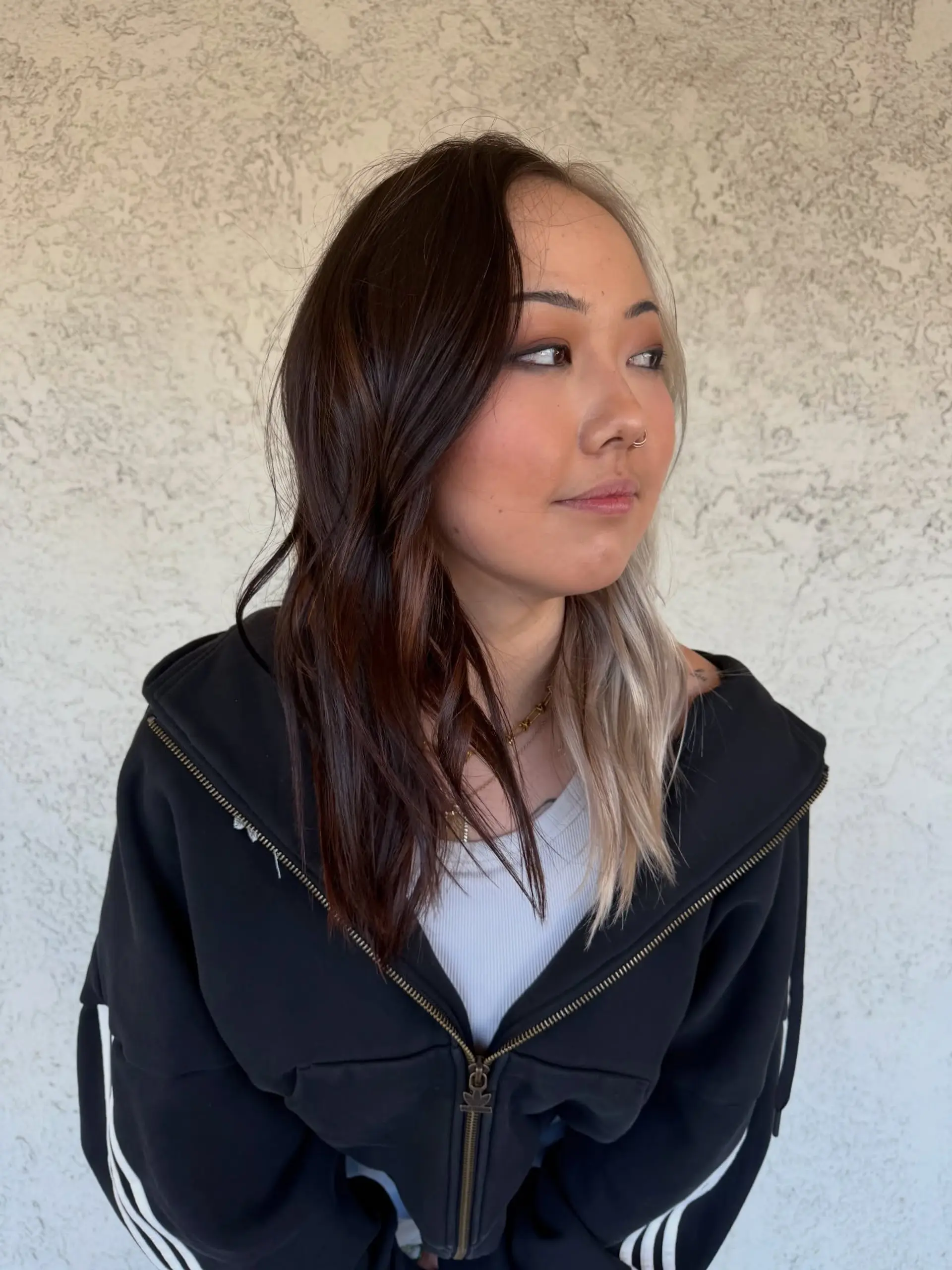 A medium-length split-dye hairstyle featuring rich dark brown on one side and contrasting platinum blonde on the other. 1