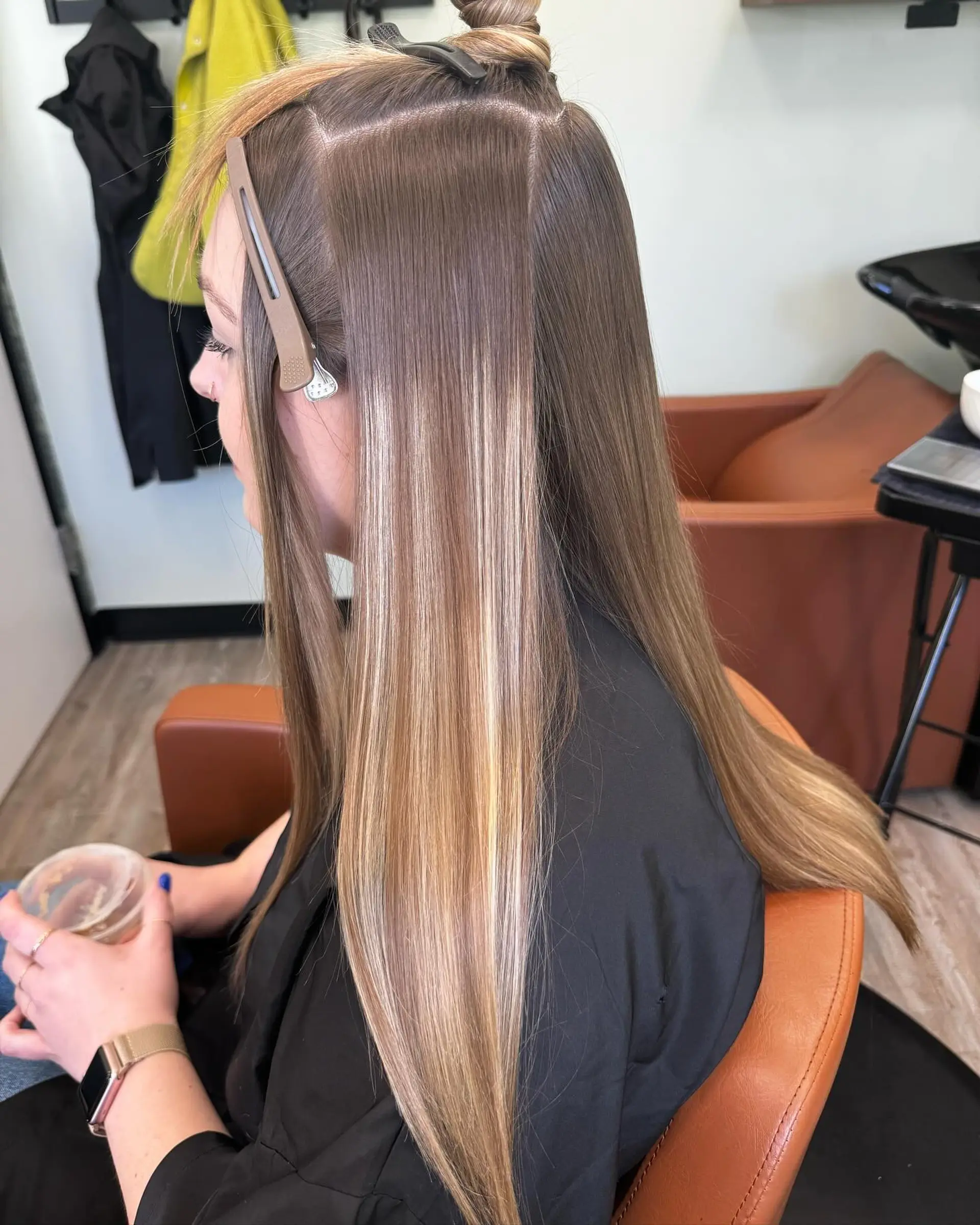 Long straight hair featuring a seamless blonde foilayage and color melt over an ash light brown base. 1