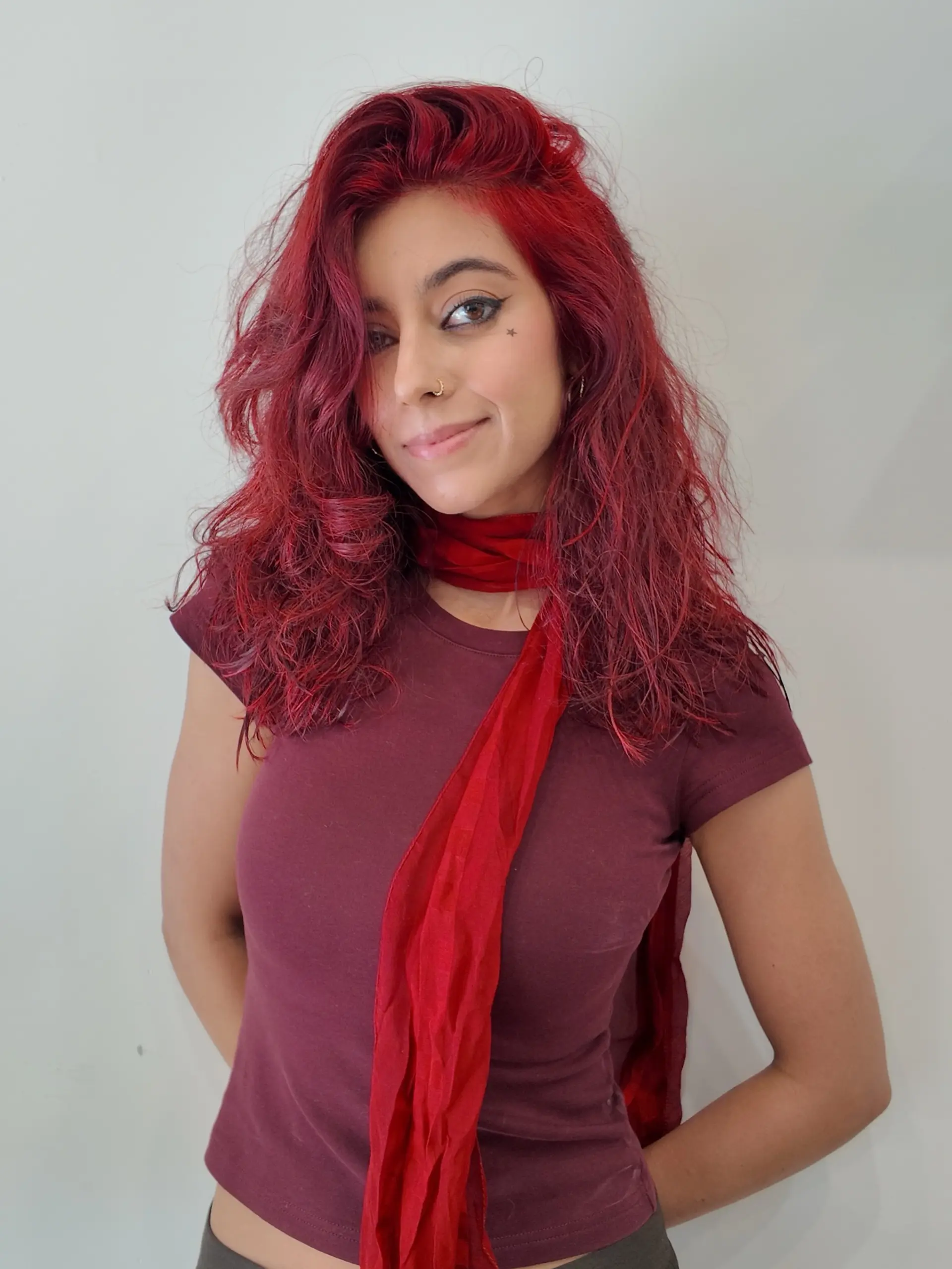 Medium-length textured haircut featuring voluminous waves dyed in an eye-catching, vibrant crimson red shade. 1
