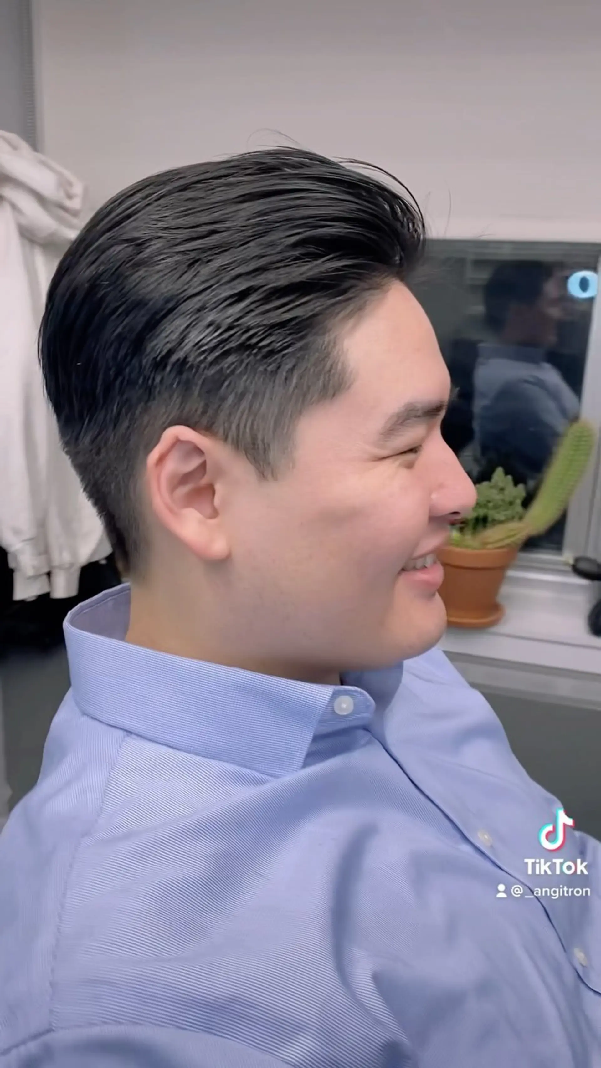 A sleek, classic men's haircut featuring hair styled smoothly back with neatly tapered sides. 1