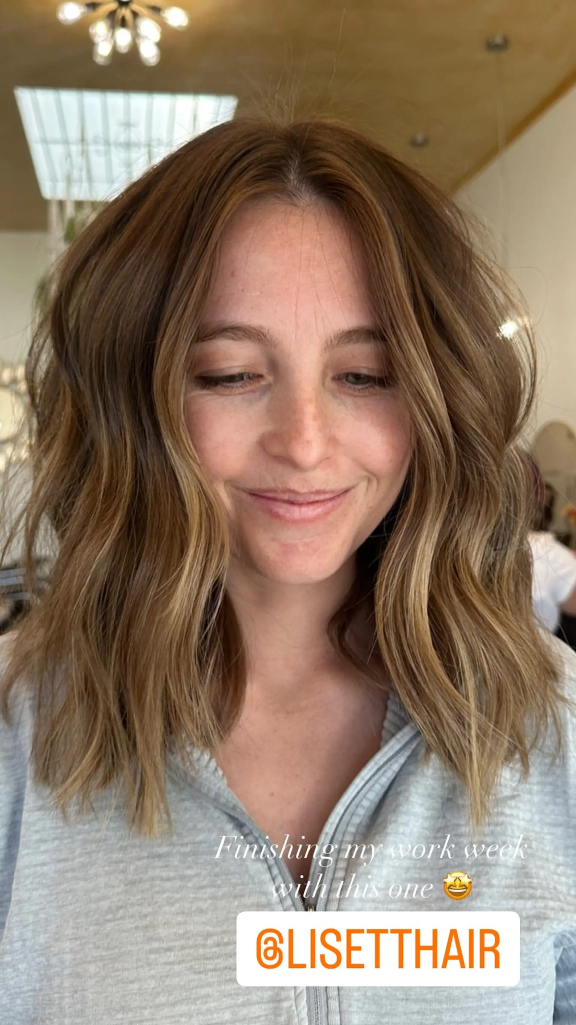 A medium-length wavy hairstyle with face-framing caramel and blonde highlights. 1