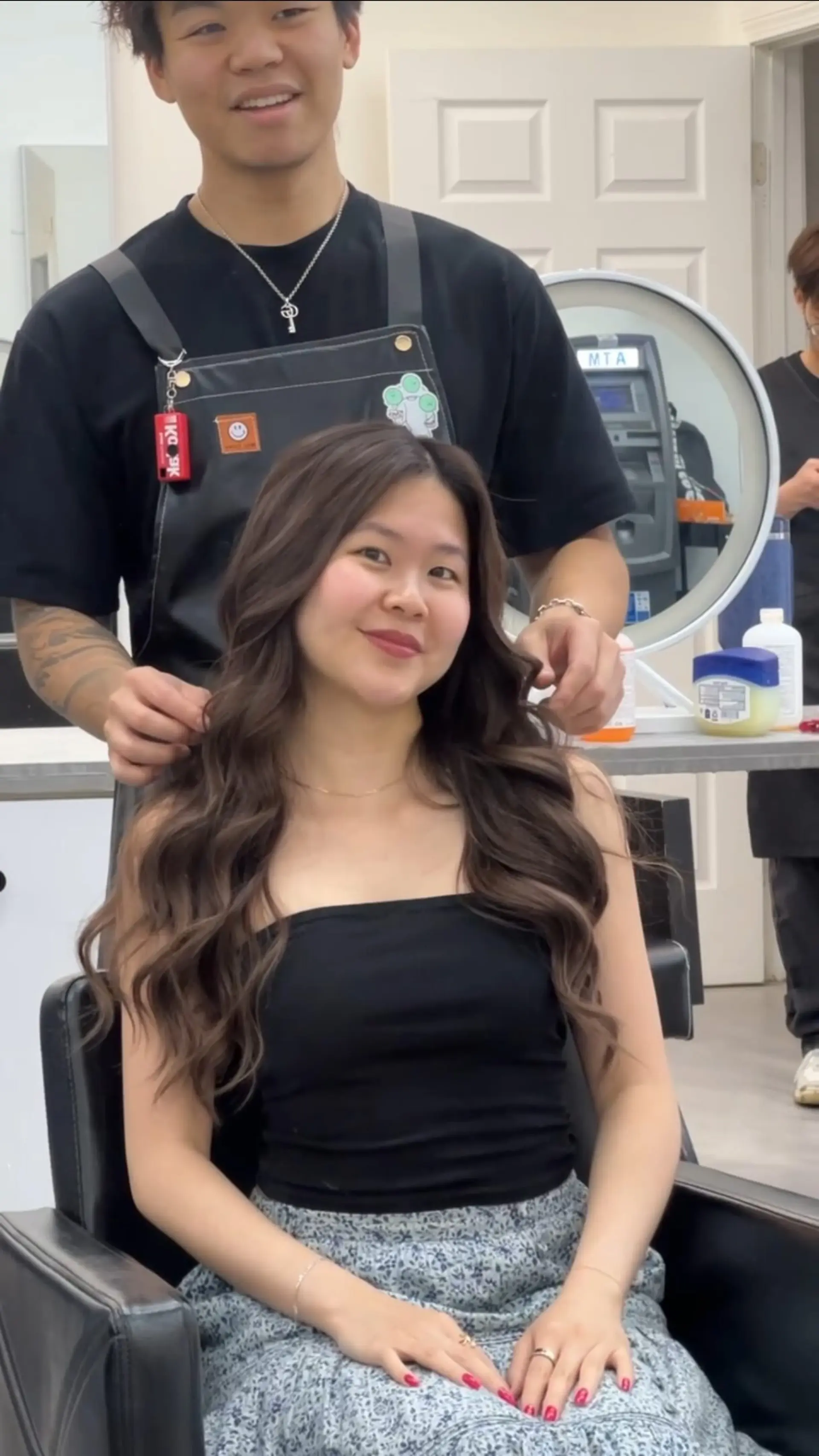 Long dark brown hair styled in soft, voluminous waves with a center part. 1