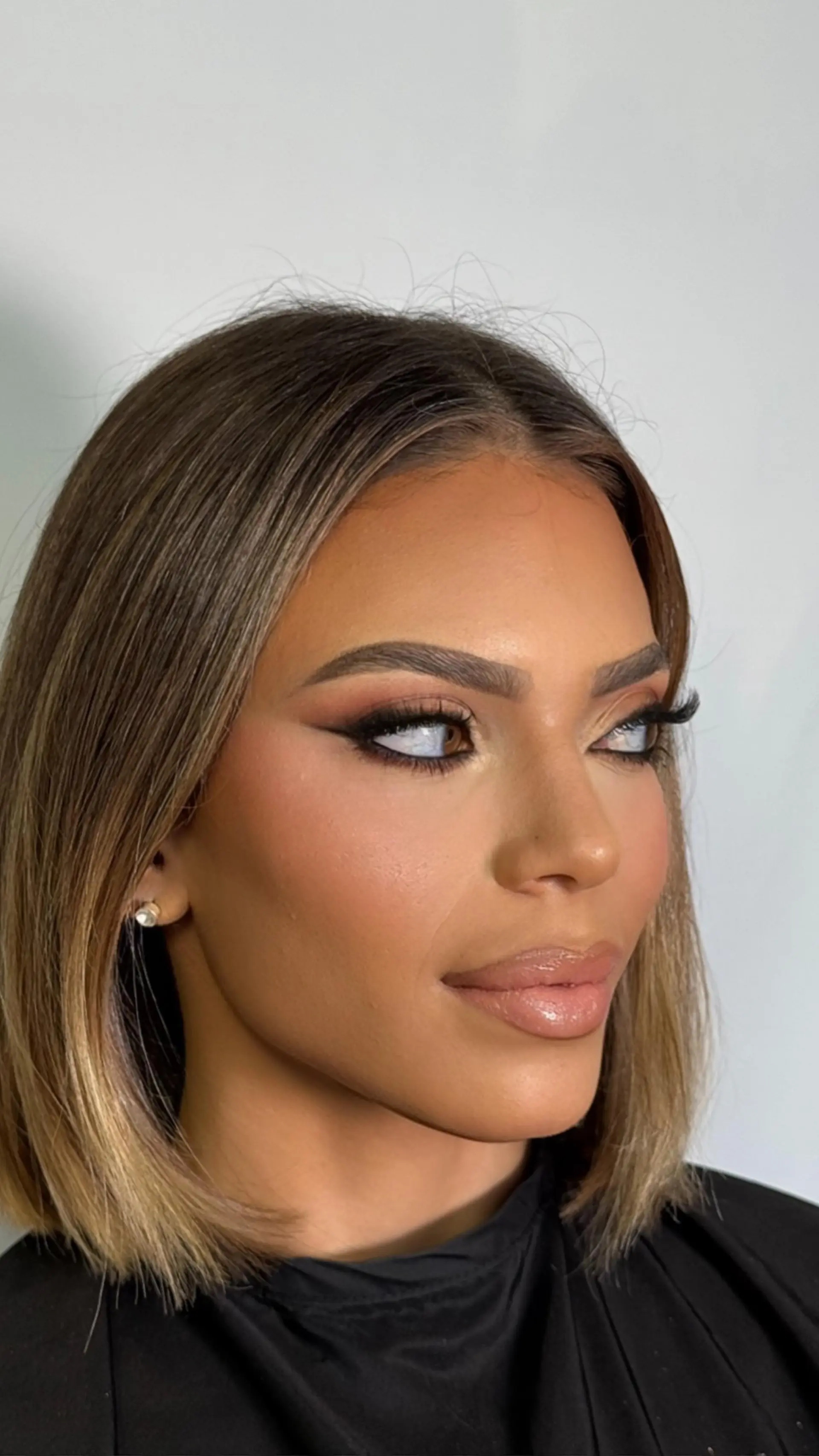 A sleek, smooth long bob with a middle part, showcasing subtle warm caramel and light brown balayage highlights. 1