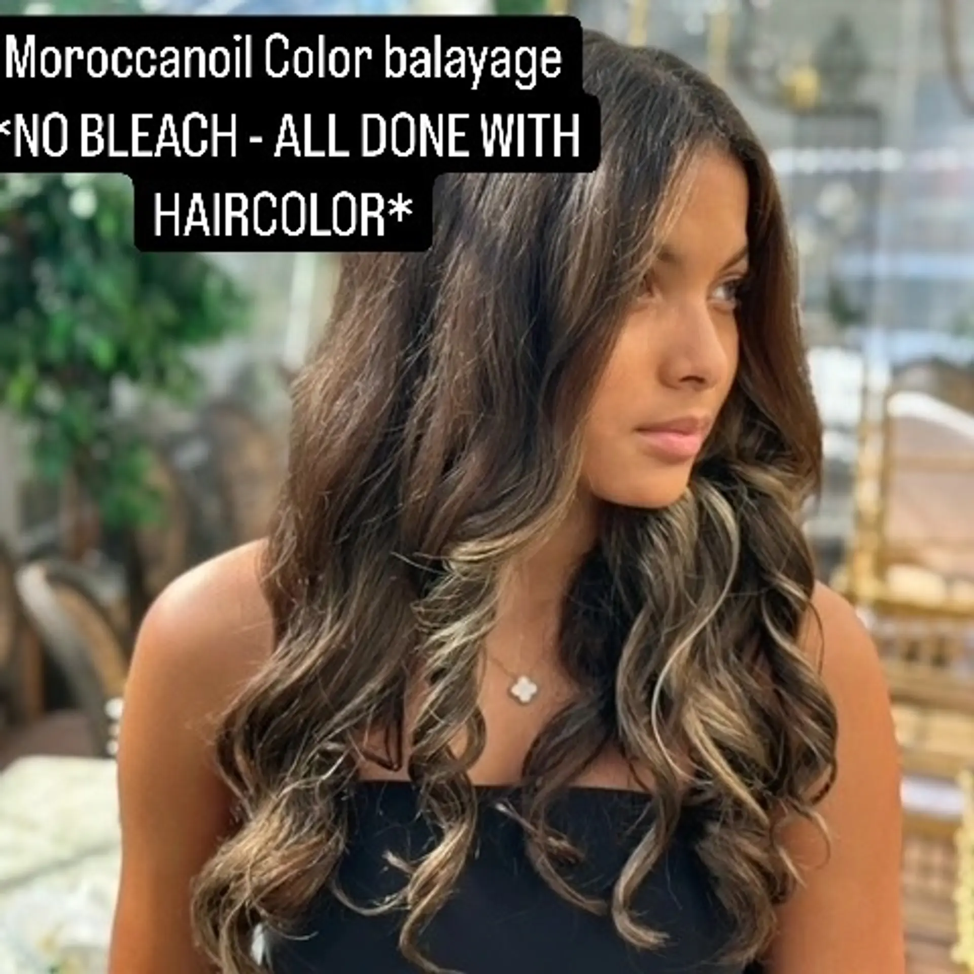 Long dark brunette hair featuring delicate caramel balayage highlights styled in bouncy curls. 1