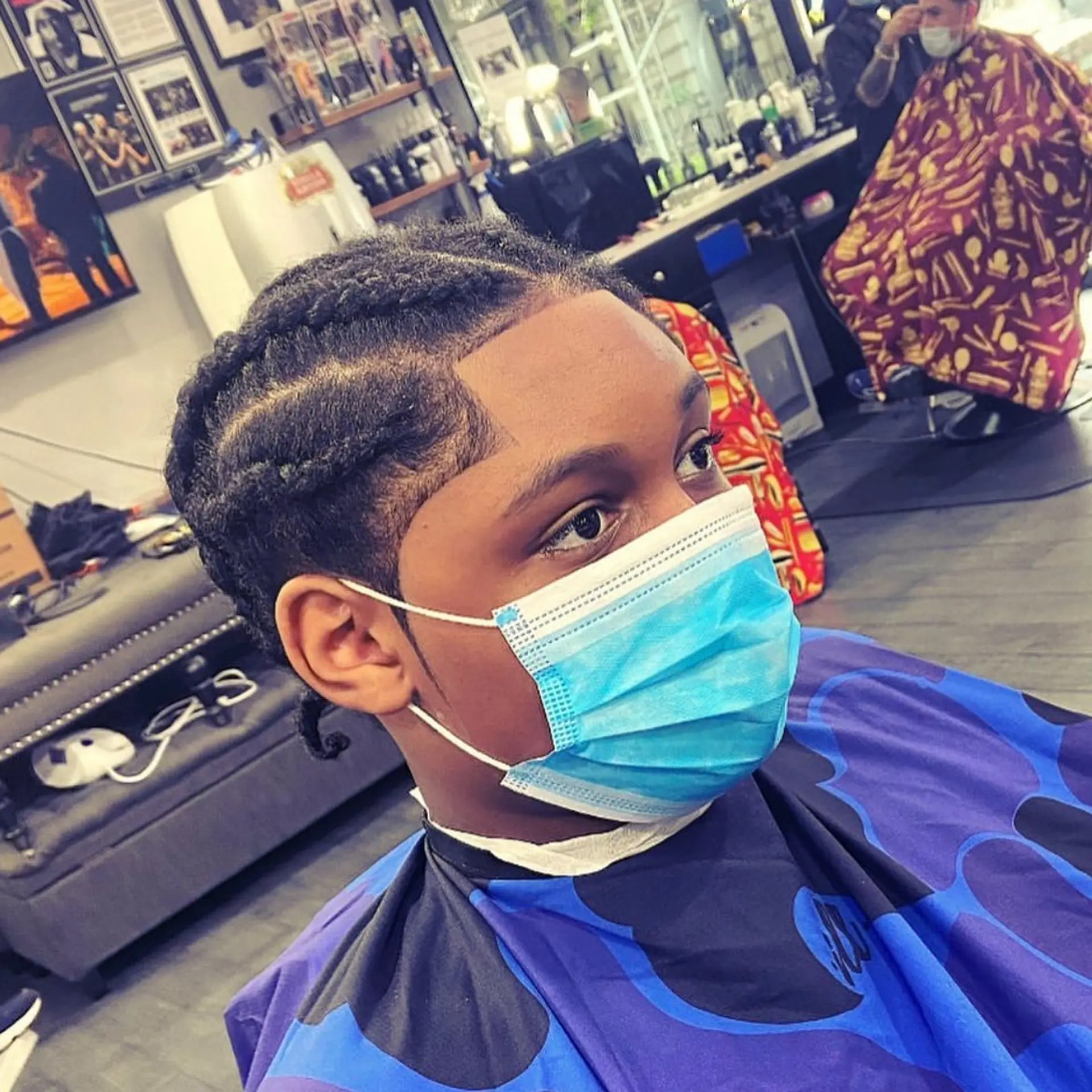 Neat cornrow braids styled on top accompanied by a sharply defined, clean edge-up along the hairline and temples. 1