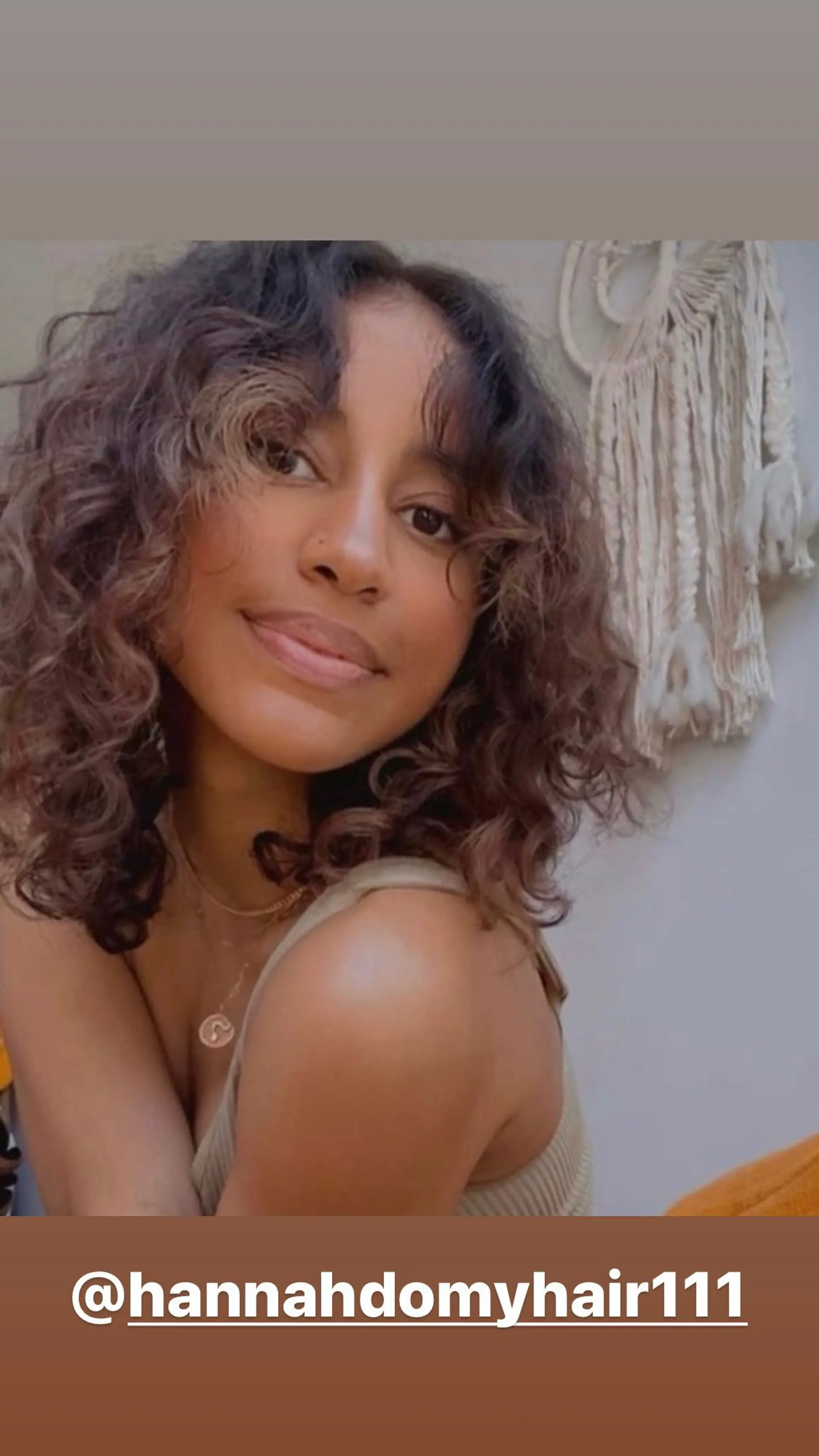 A medium-length curly shag haircut with fringe and dimensional color. 1