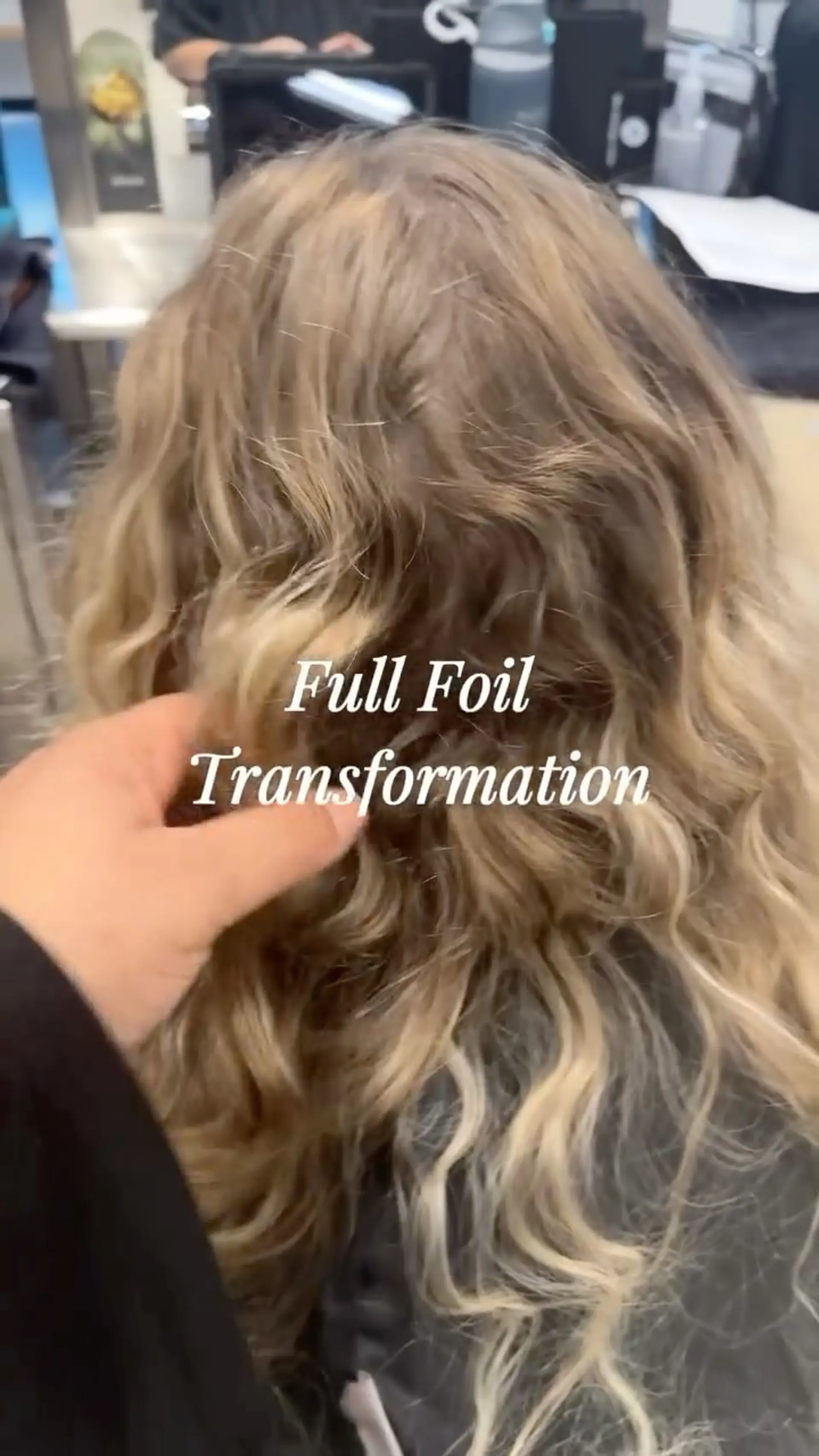 Long wavy hair styled with dimensional full foil golden blonde highlights throughout. 1