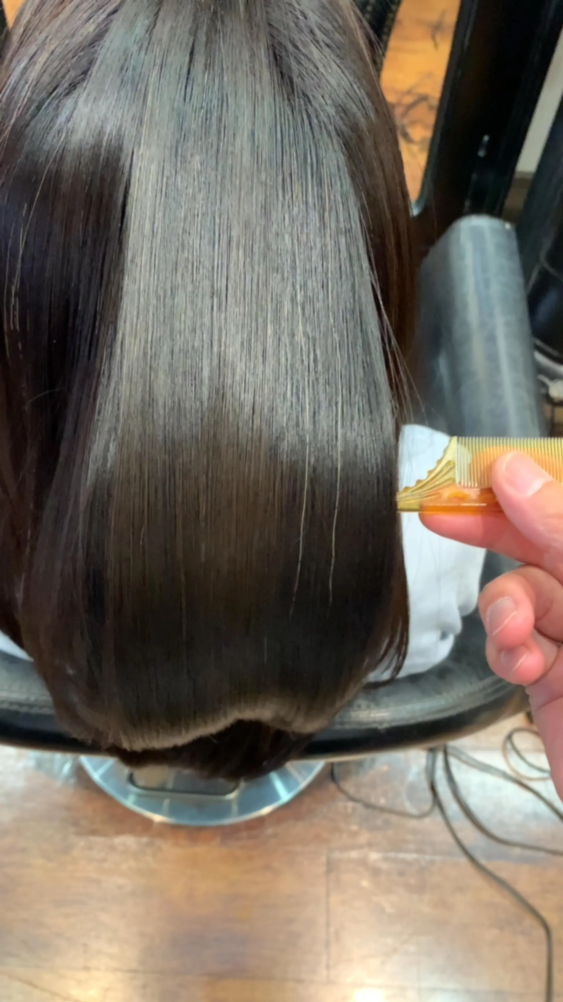 Ultra-smooth, glossy dark hair styled sleek and straight with high shine. 1