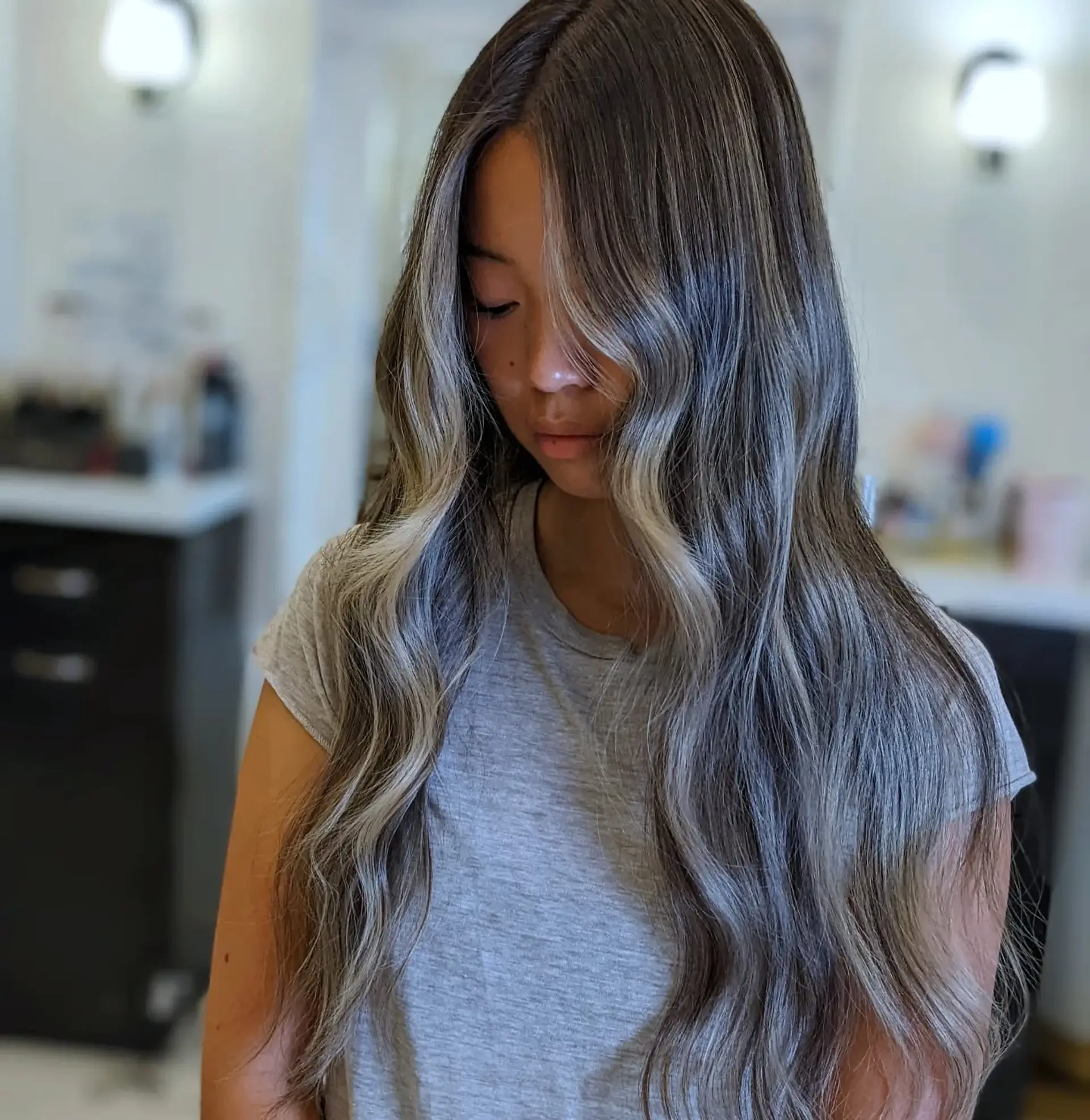Long, wavy hair with ash brown base, silver and blonde balayage, and bright blonde face-framing highlights. 1