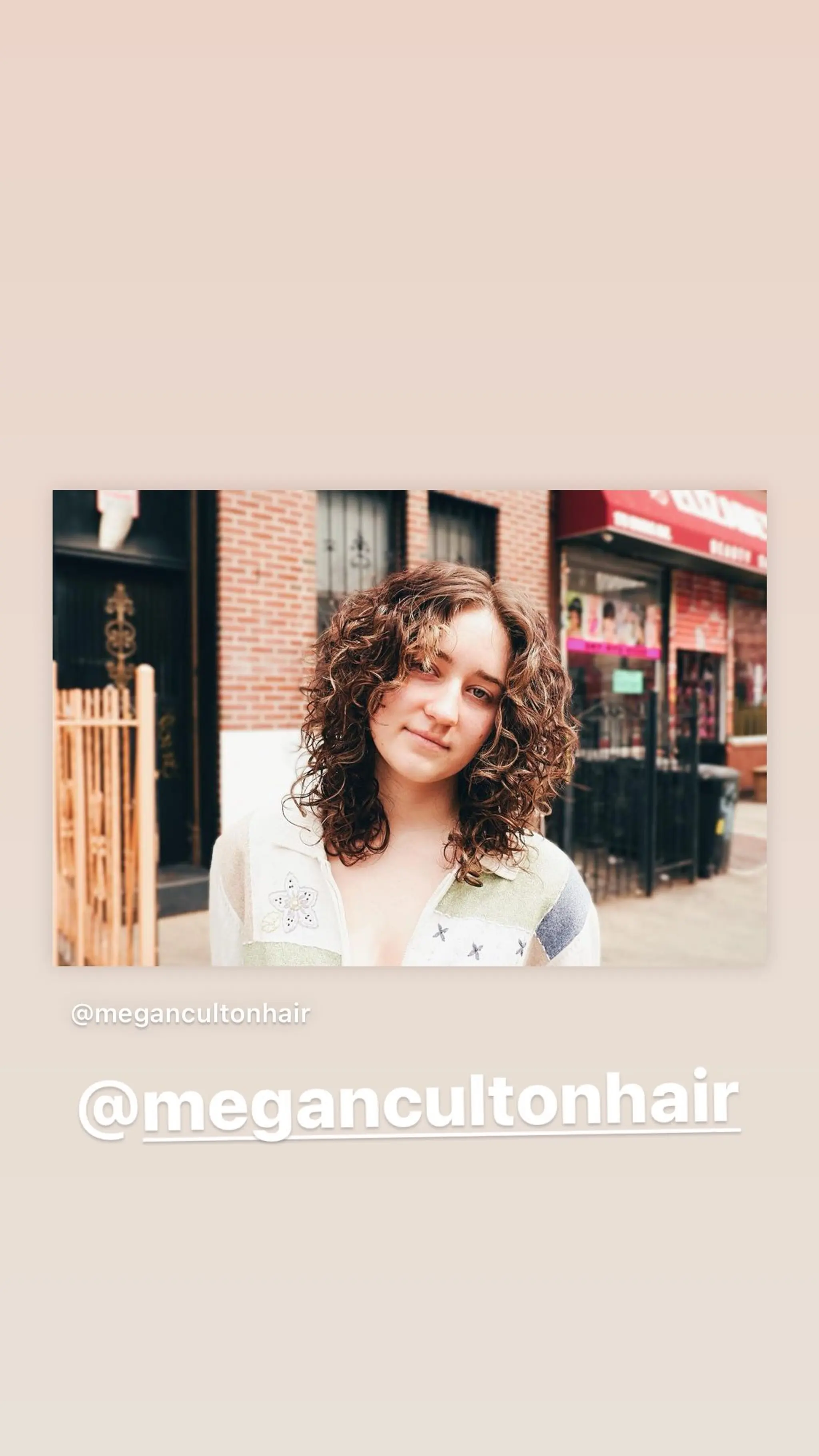 A trendy mid-length shag haircut with curly hair and full fringe bangs. The layers enhance the natural curl pattern and create a voluminous, carefree look.