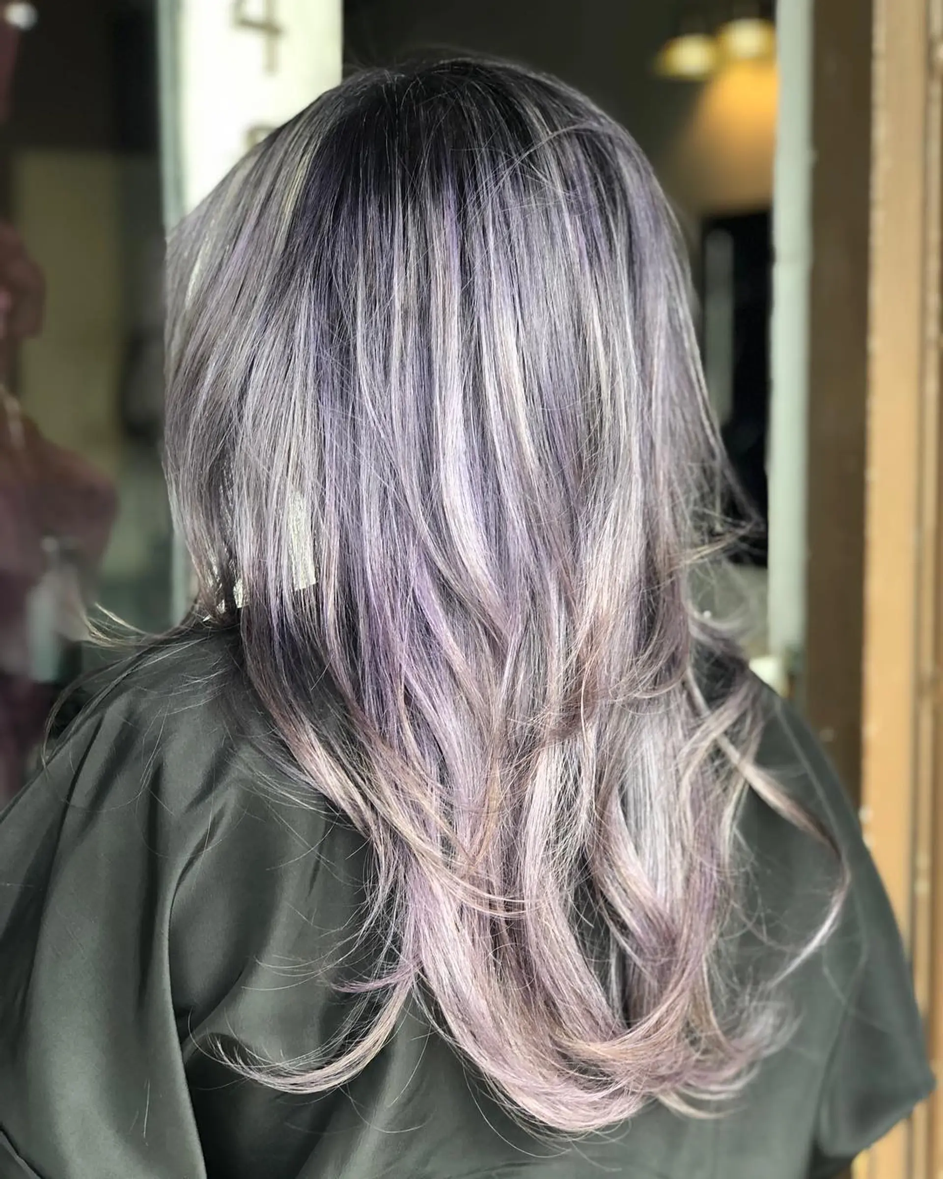 A long, multi-layered hairstyle featuring a deep dark root melting into soft lilac and silver-toned highlights with gently flipped ends. 1
