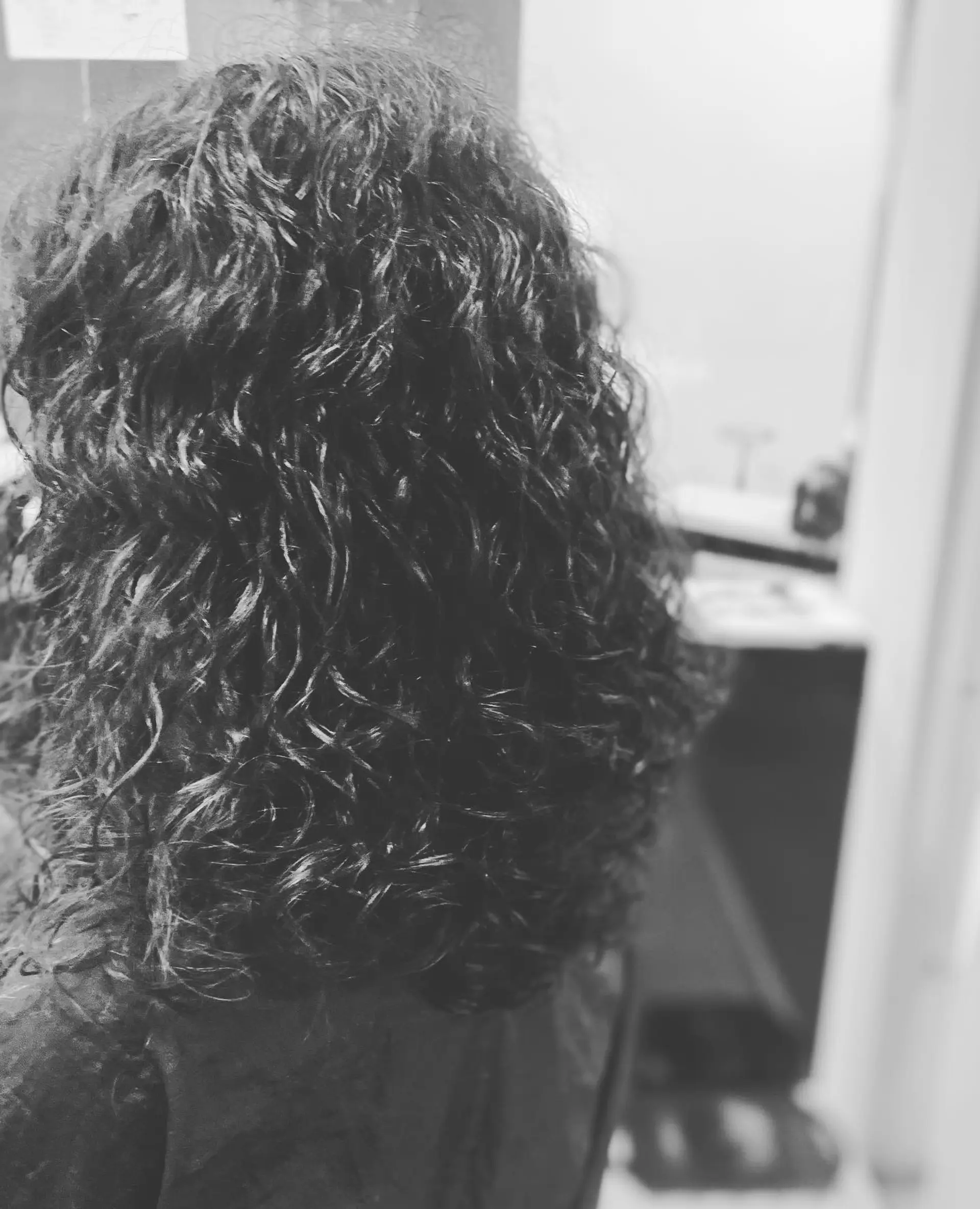 Medium-length layered curly hairstyle with defined ringlets and natural volume. 1