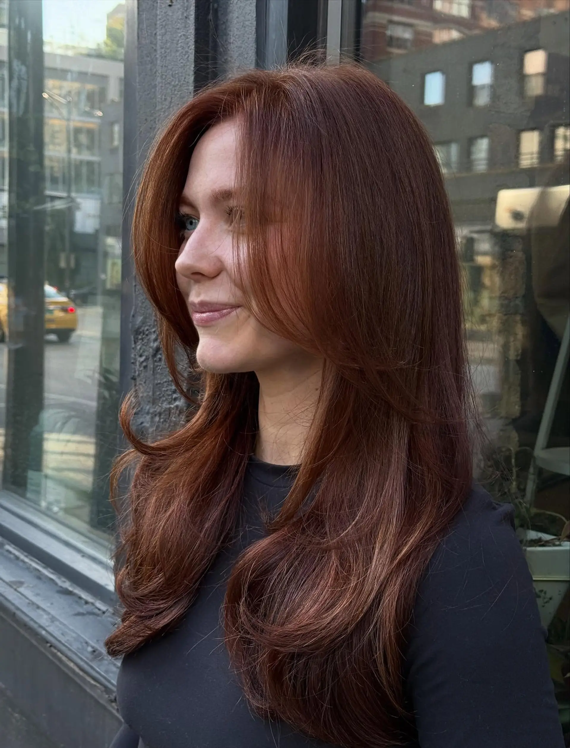 Rich copper long hair styled into voluminous face-framing layers with smooth, curved ends. 1