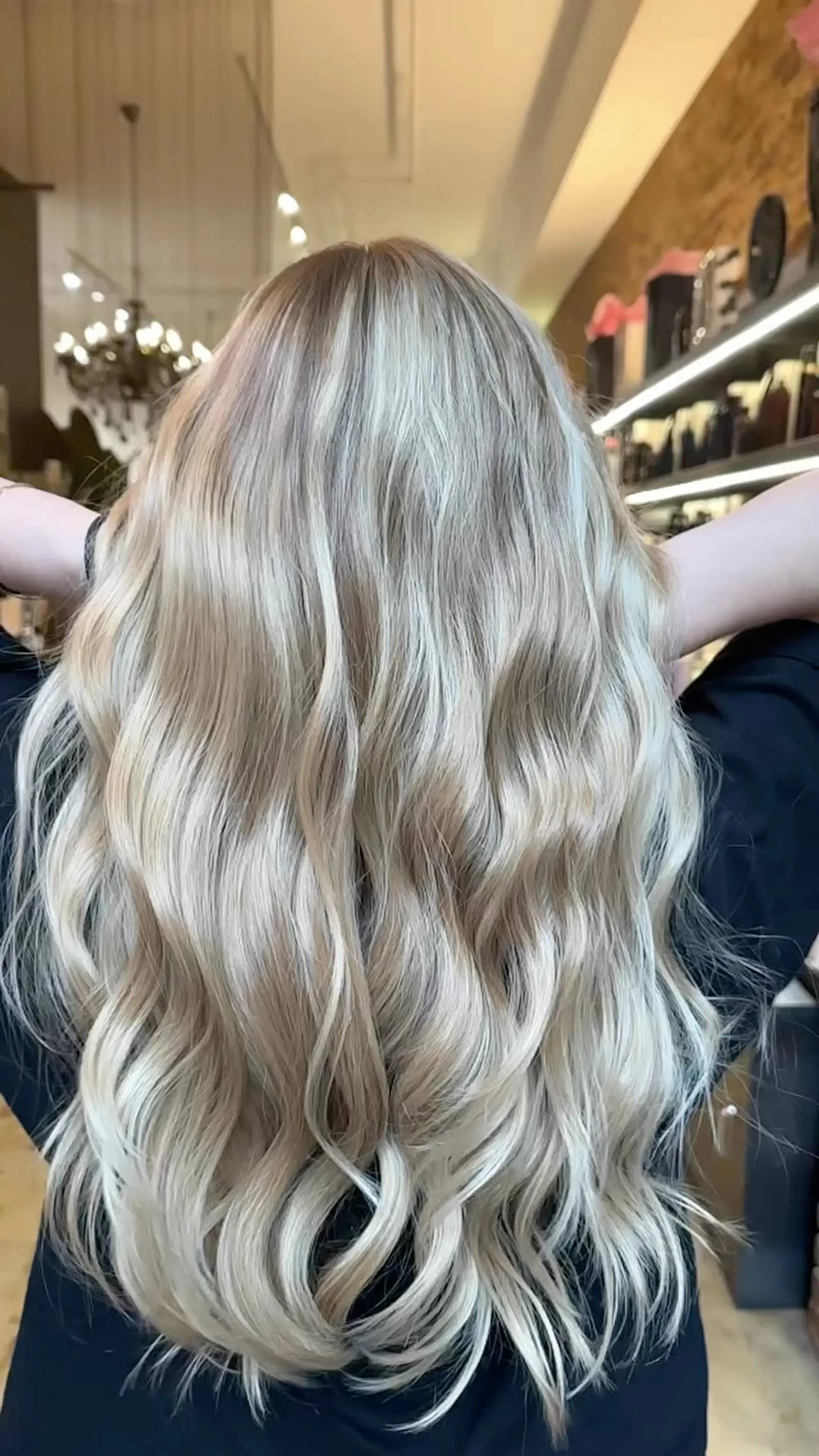 A bright, cool-toned ash blonde balayage with soft, dimensional waves. 1
