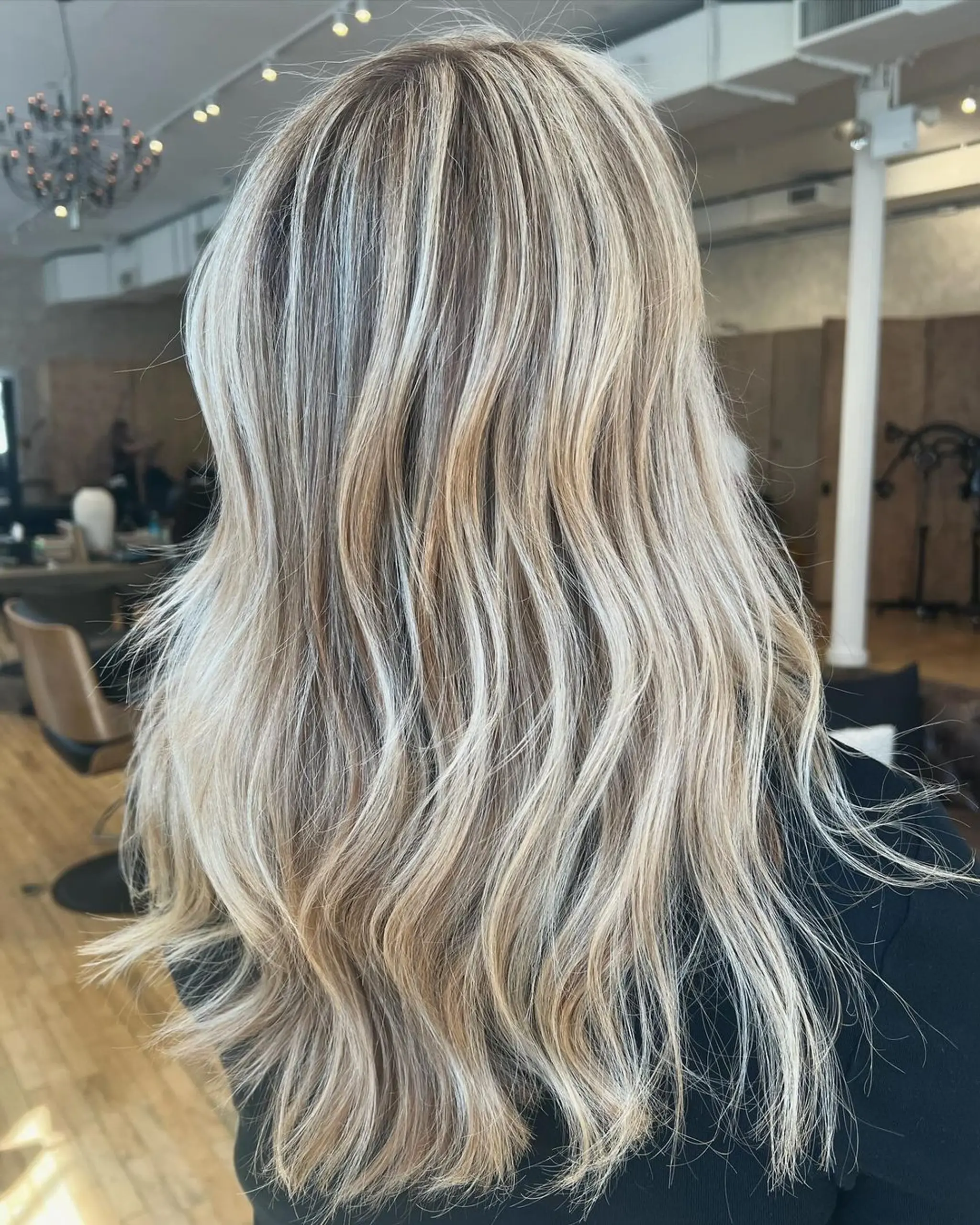 Long, wavy blonde hair with platinum highlights and honey lowlights, featuring a layered cut and beachy, natural waves.

Stylist: @danieldoeshair