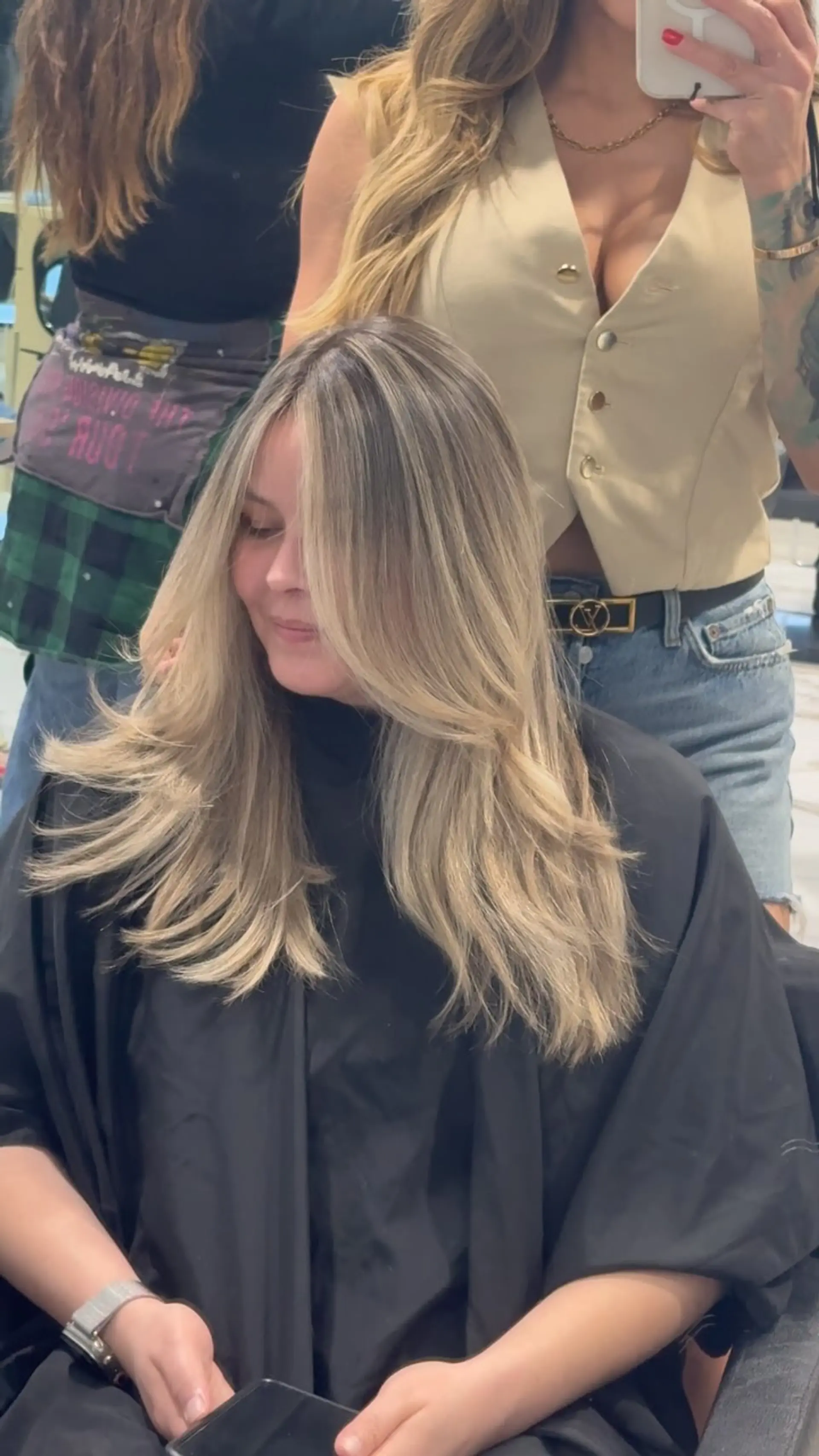 Long ash blonde hair styled with cascading layers and soft, face-framing curtain bangs. 1