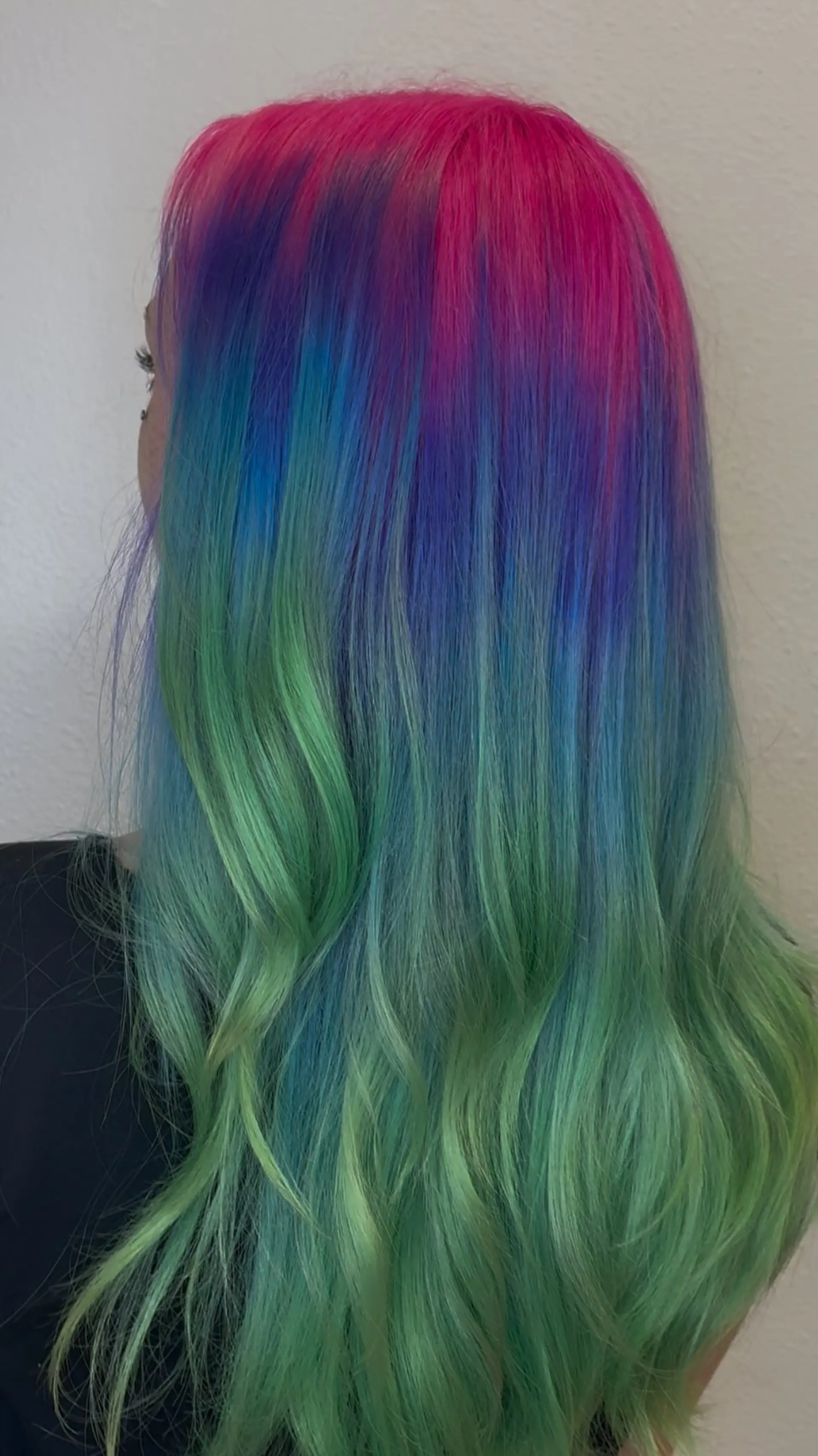 Long wavy hair featuring a seamless vivid color melt from hot pink roots into blue and mint green. 1