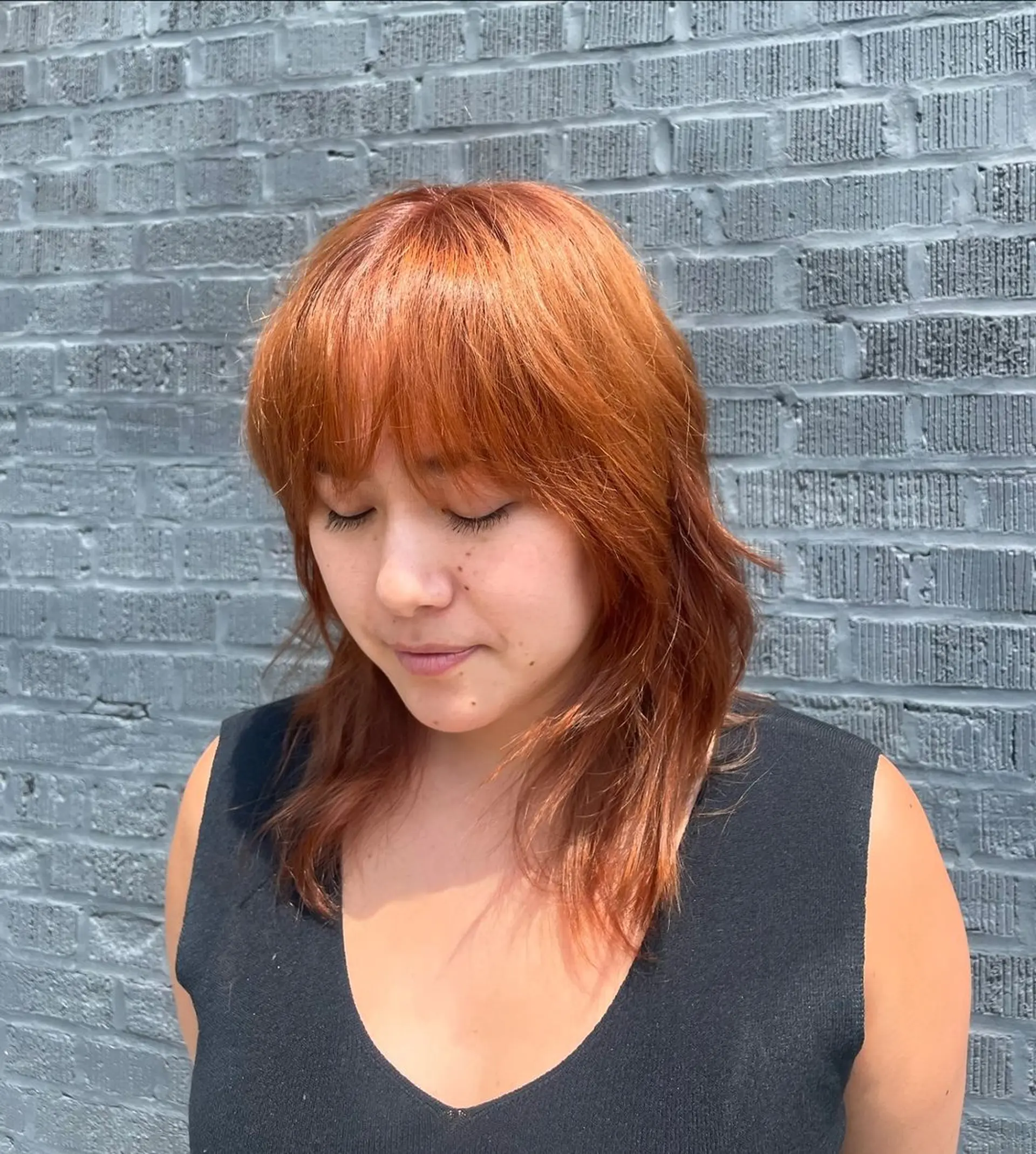 Medium-length cut with soft waves and a textured fringe, featuring a vibrant copper color. 1