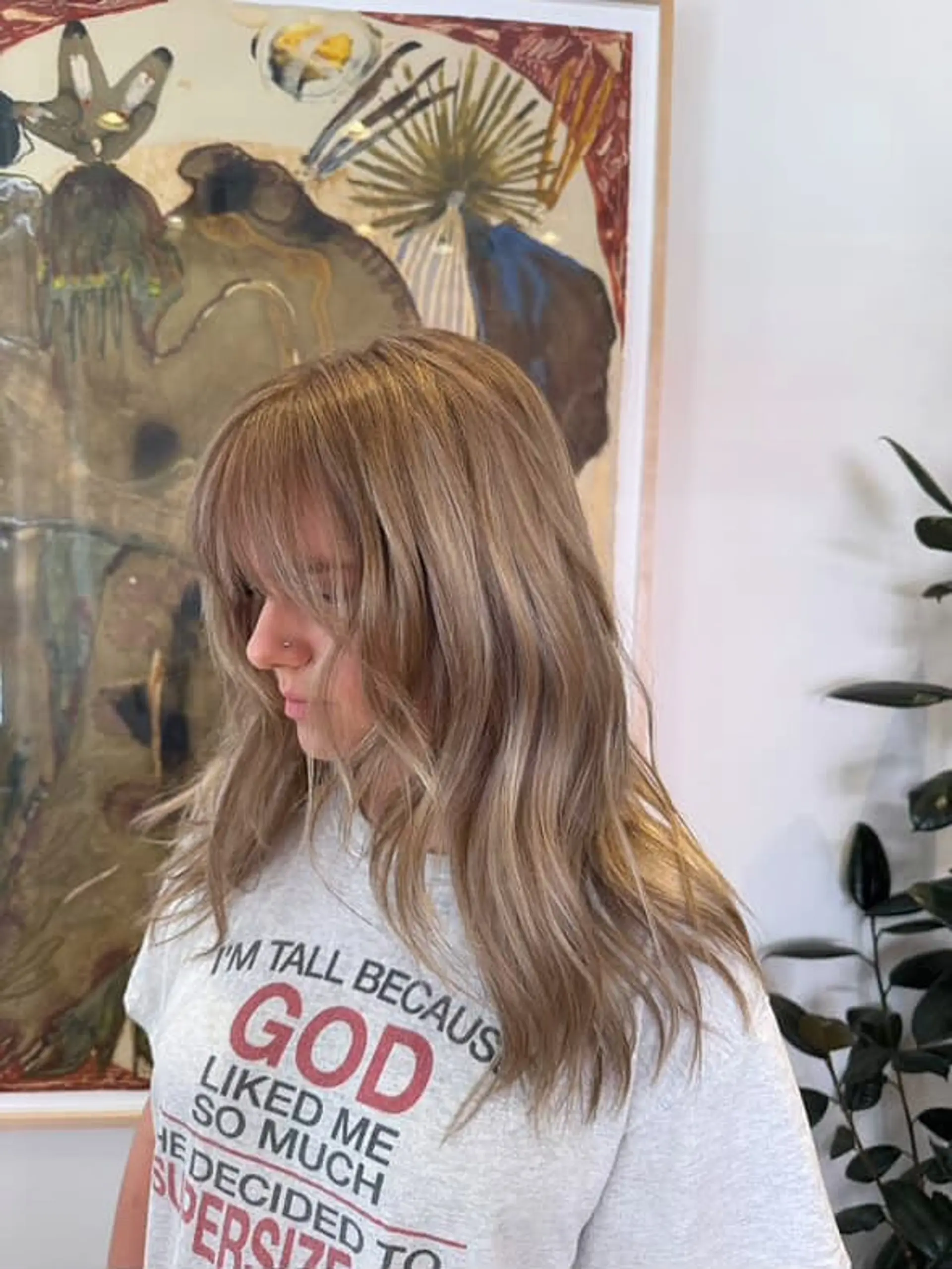 A medium-length shag haircut with layers and curtain bangs, featuring a blend of blonde and brown tones. 1