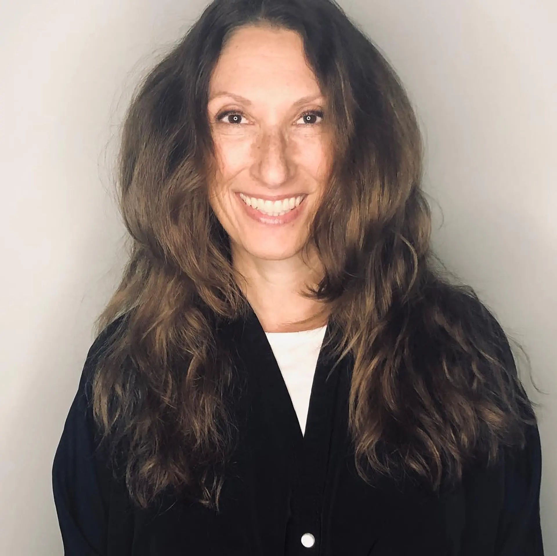 Long dimensional brunette hair cut with soft, voluminous face-framing layers and natural wavy texture. 1