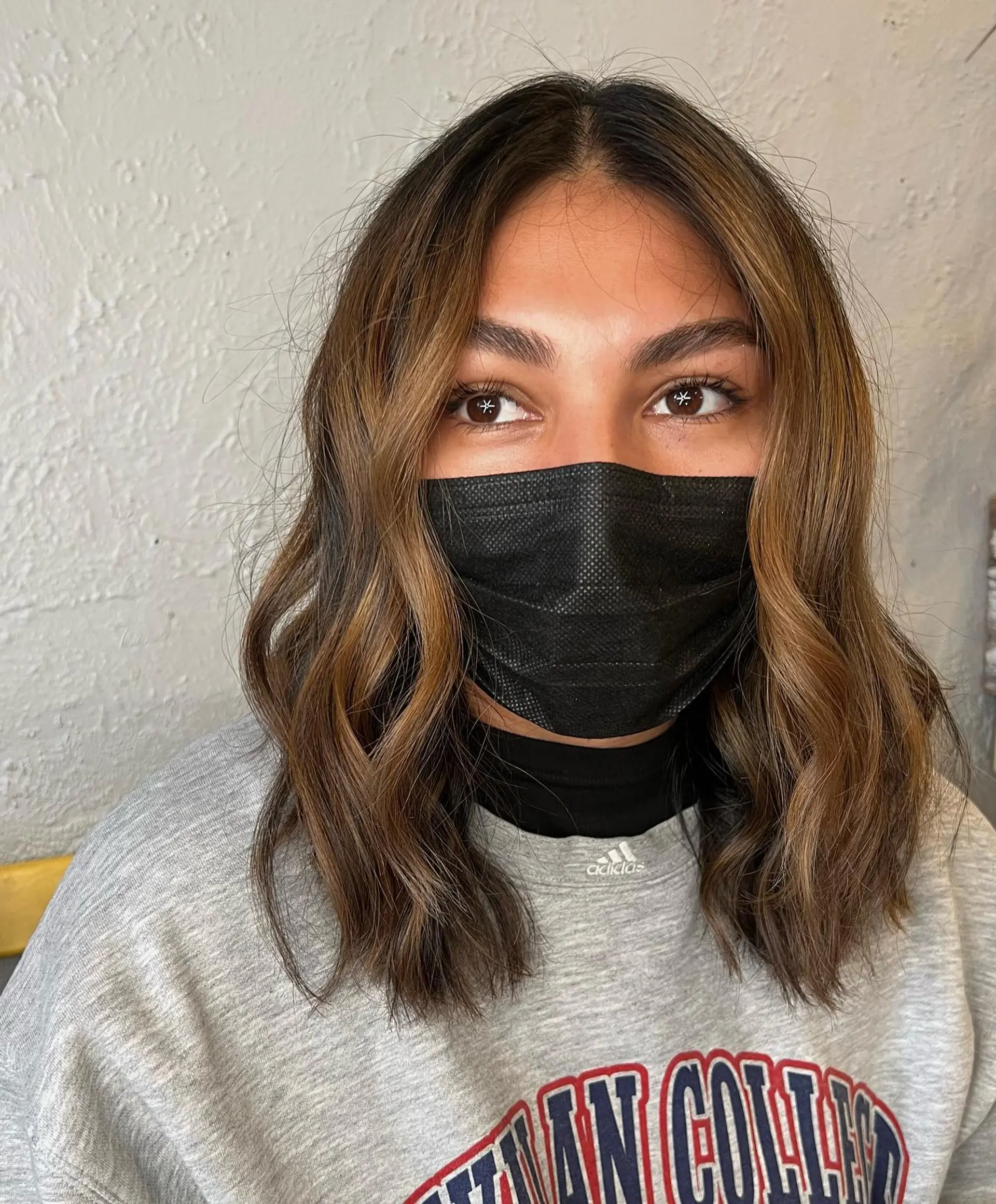 A medium-length wavy hairstyle with face-framing layers and effortless waves. 1