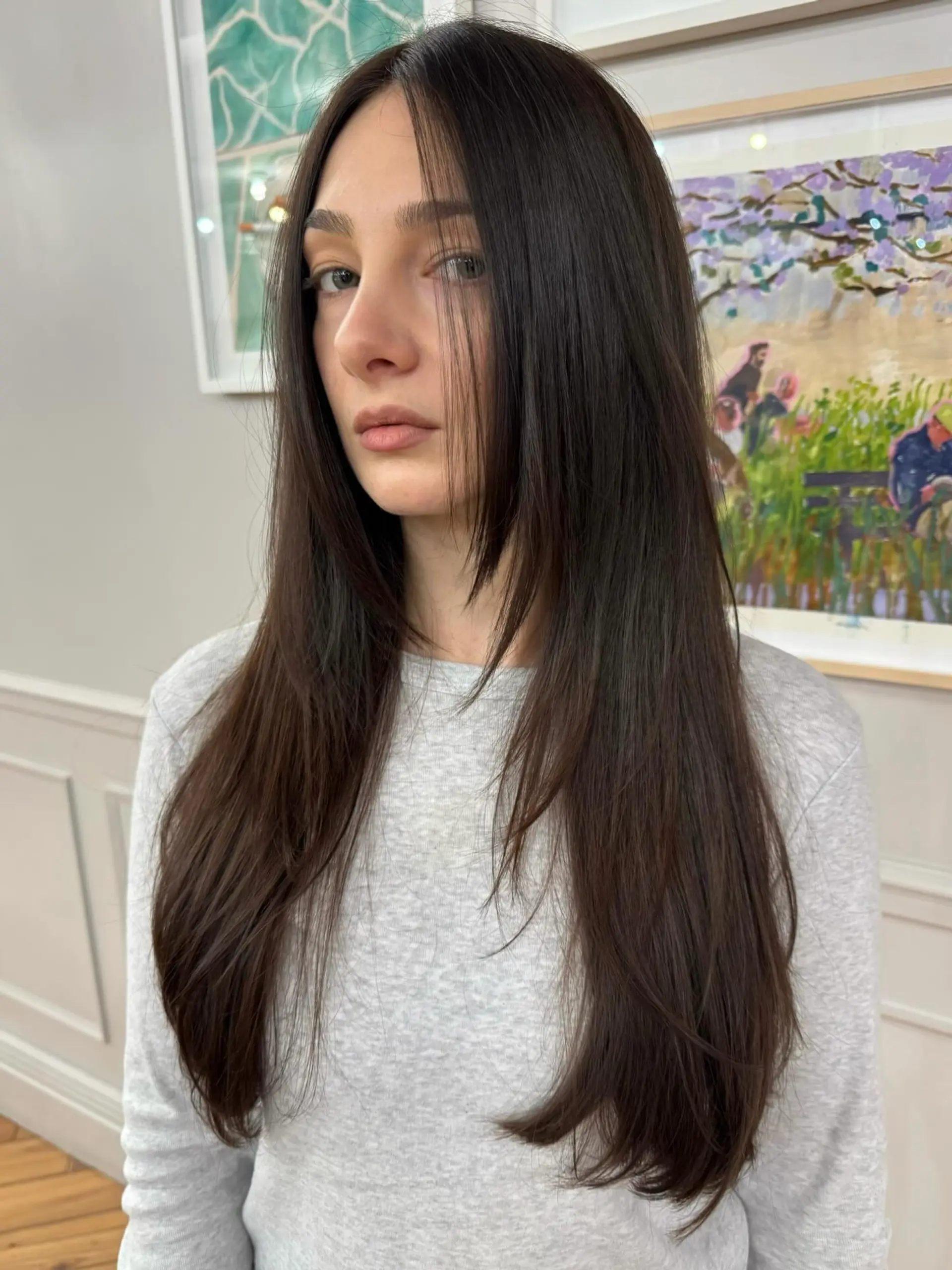 Long dark brown hair styled straight with face-framing layers. 1