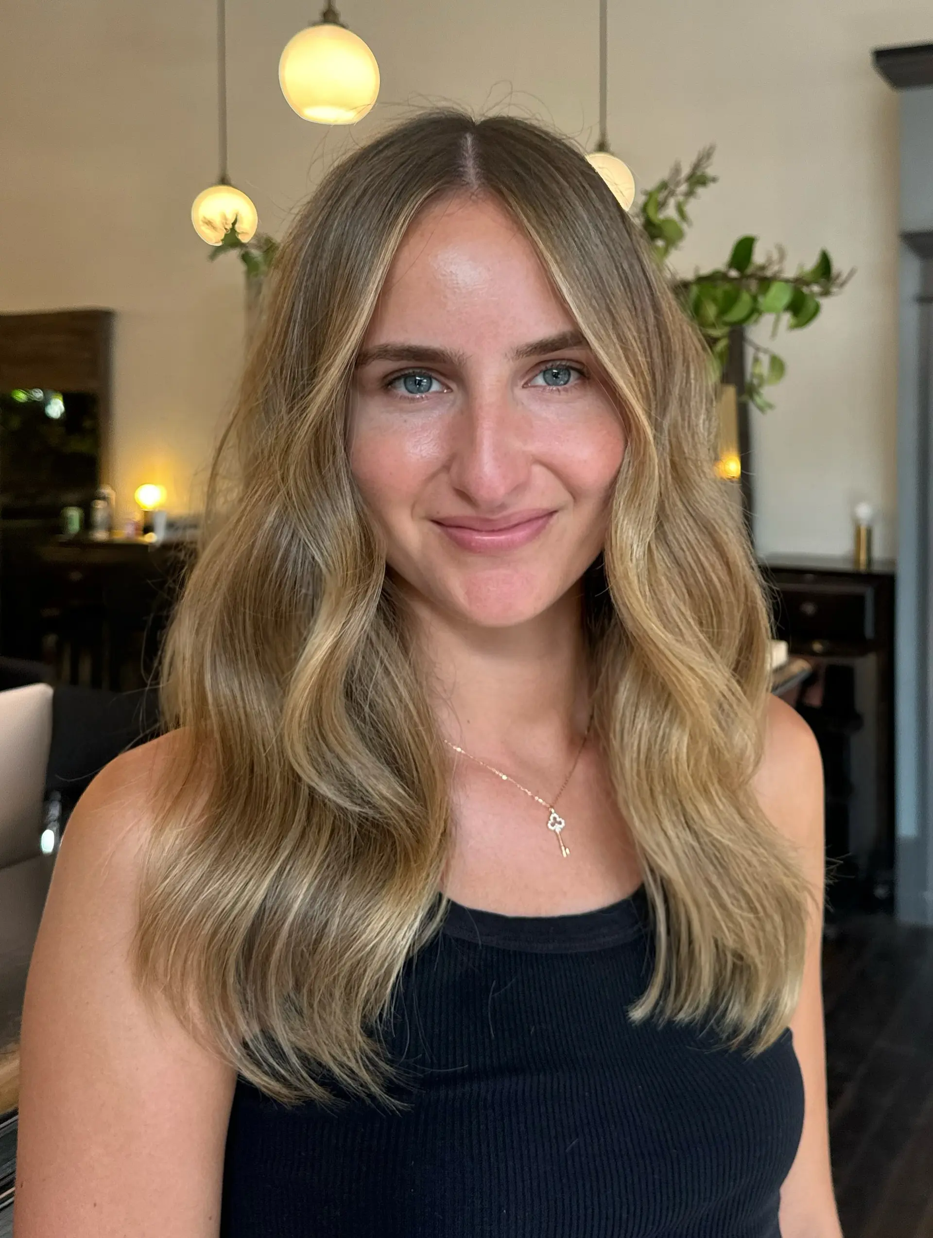 Long, dimensional bronde hair styled with a center part and soft, loose waves cascading over the shoulders. 1