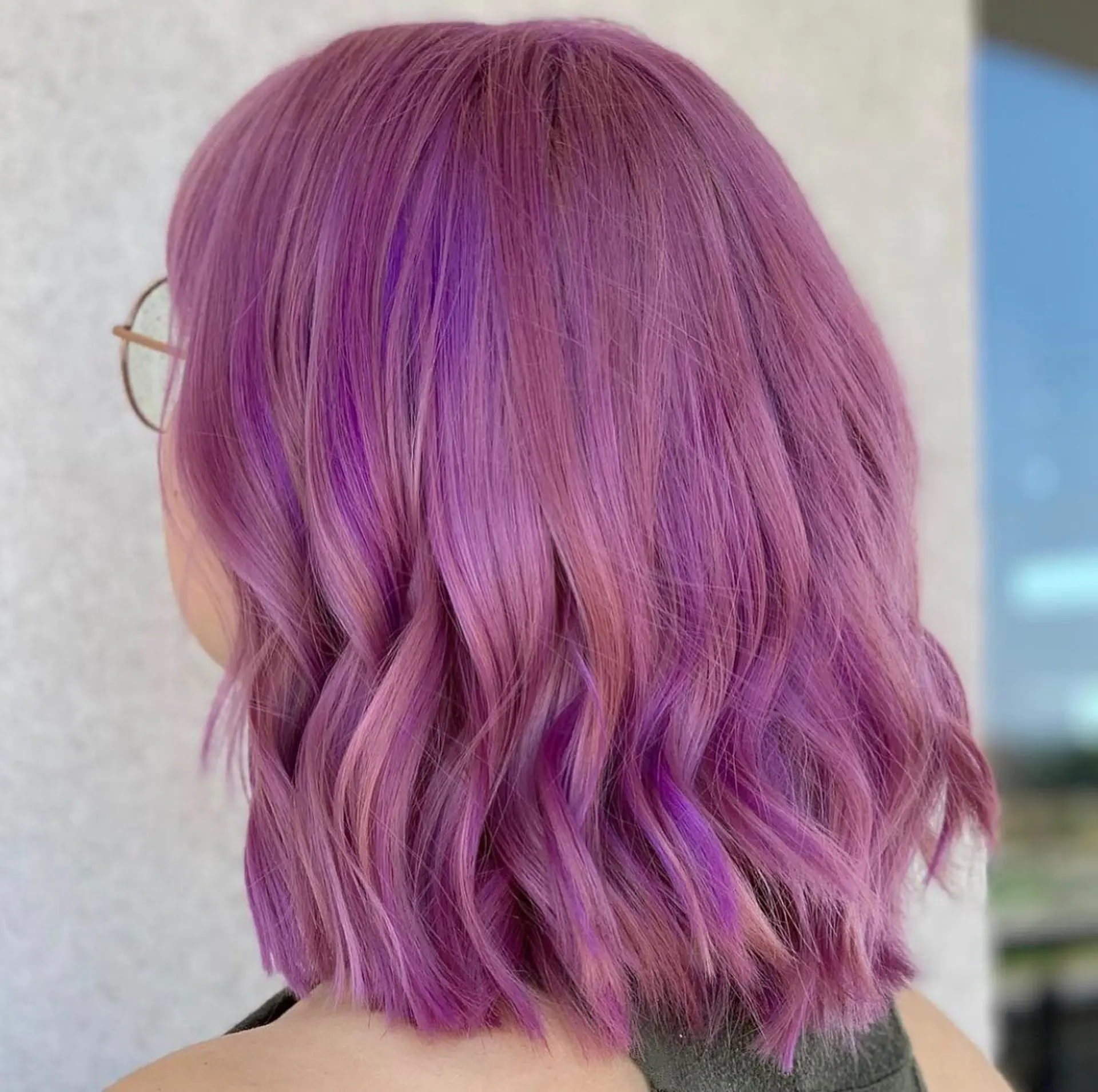 This eye-catching lob features a blend of multi-dimensional lavender and purple tones styled with soft, modern waves for a playful yet chic appearance. 1
