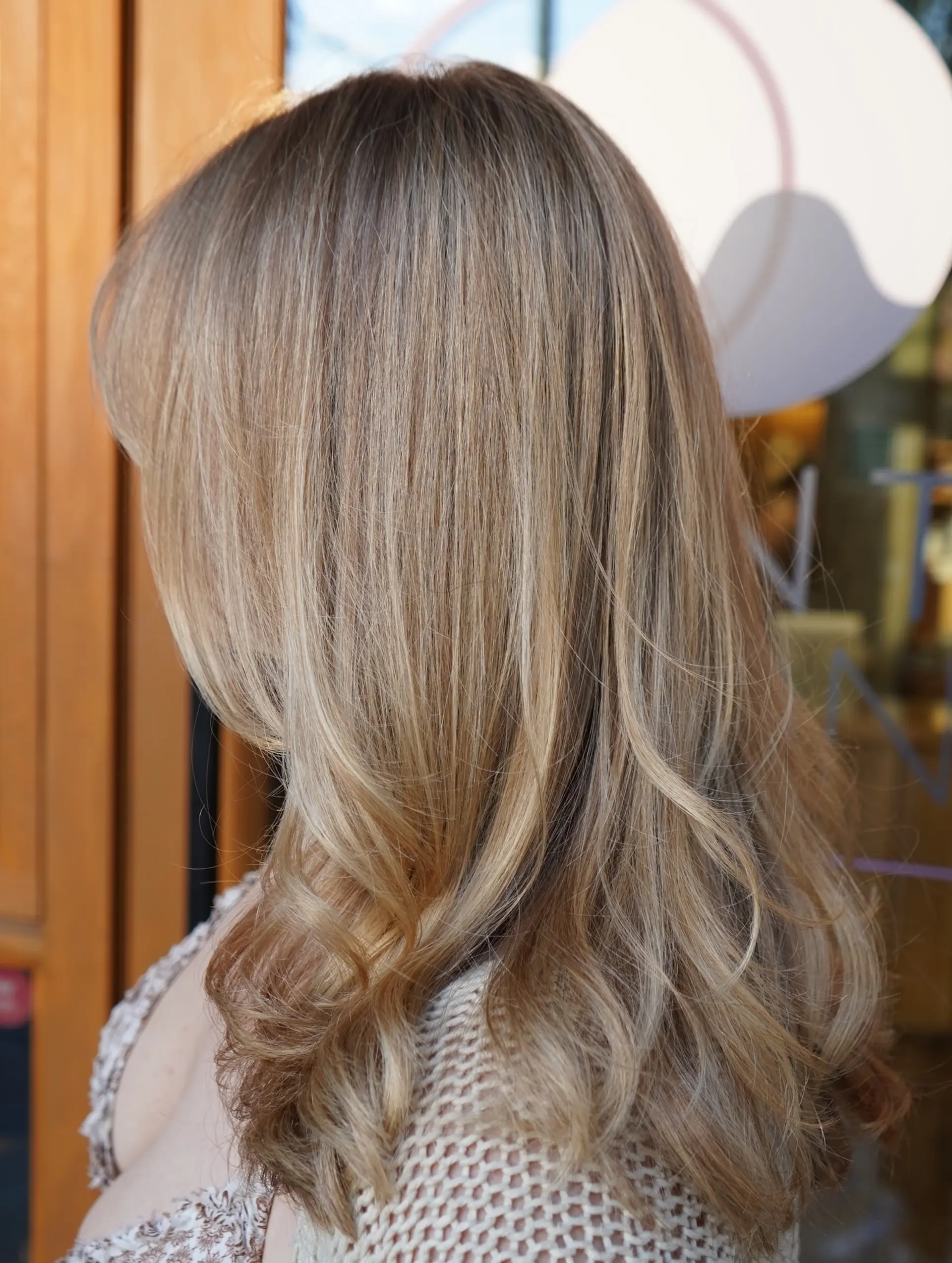 Long beige blonde hair with seamless dimensional highlights and soft curling at the ends. 1