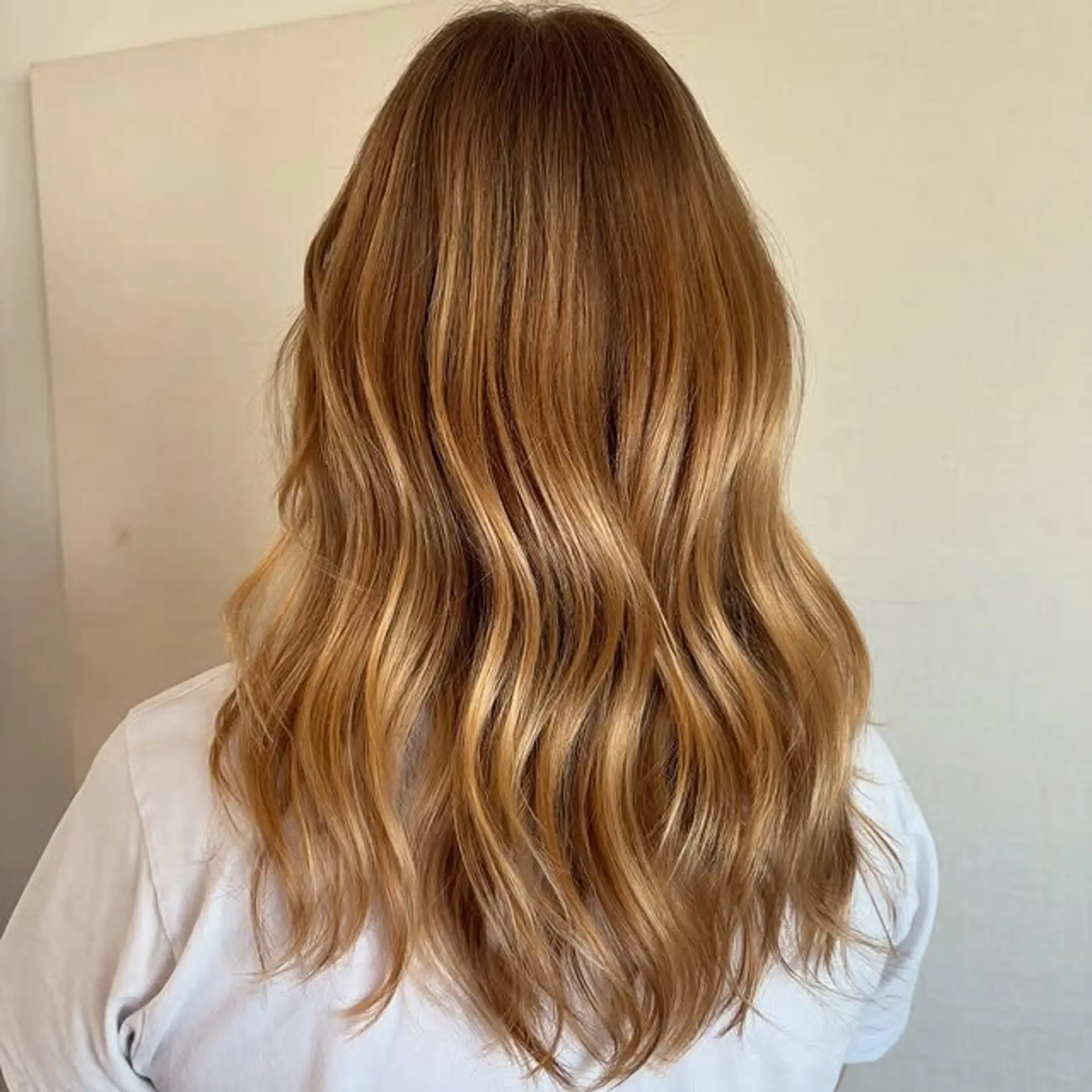 Medium length wavy hair with a honey blonde balayage and face-framing layers. 1