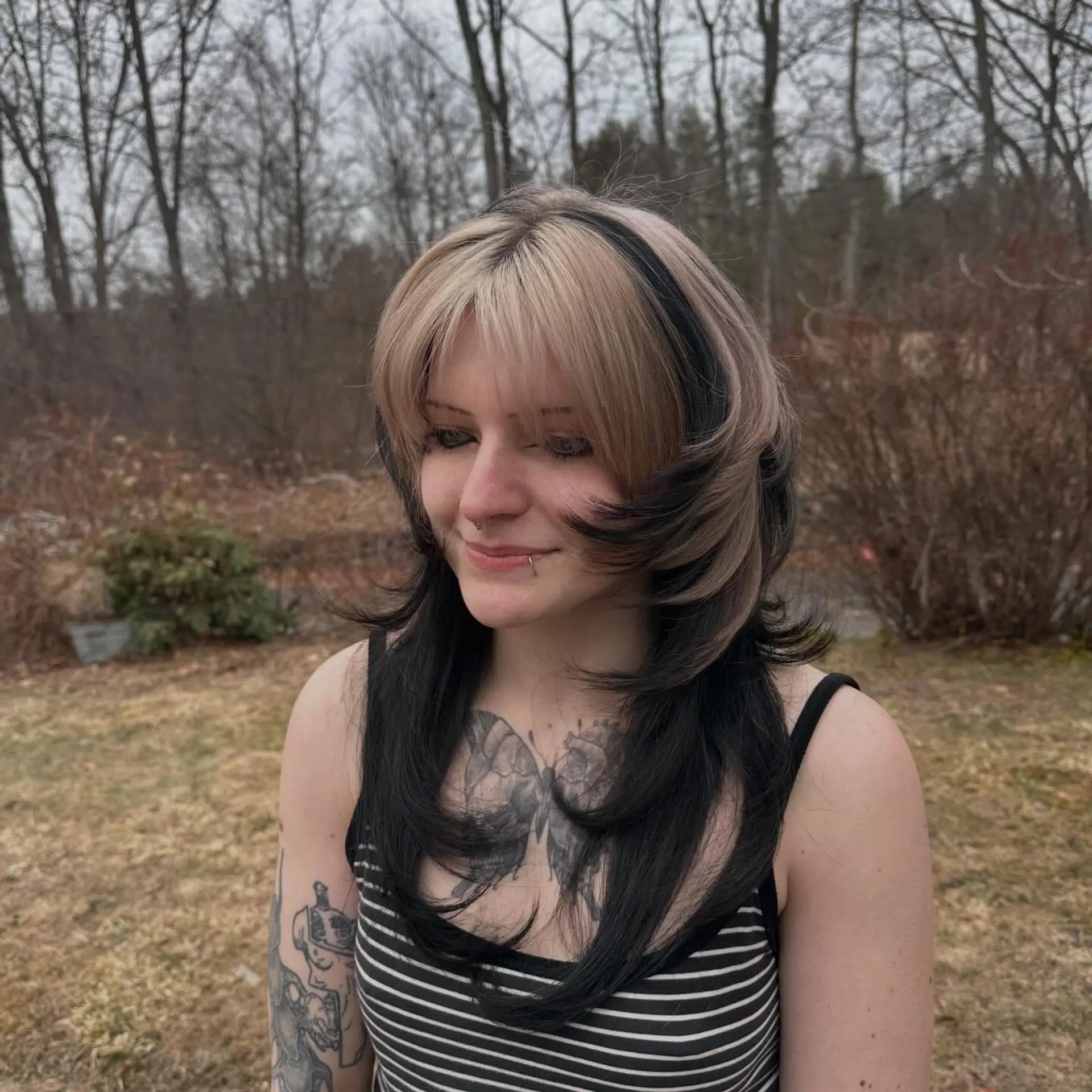 A layered jellyfish cut featuring a short, rounded top layer with bangs and elongated under-layers, styled in high-contrast blonde and black tones. 1