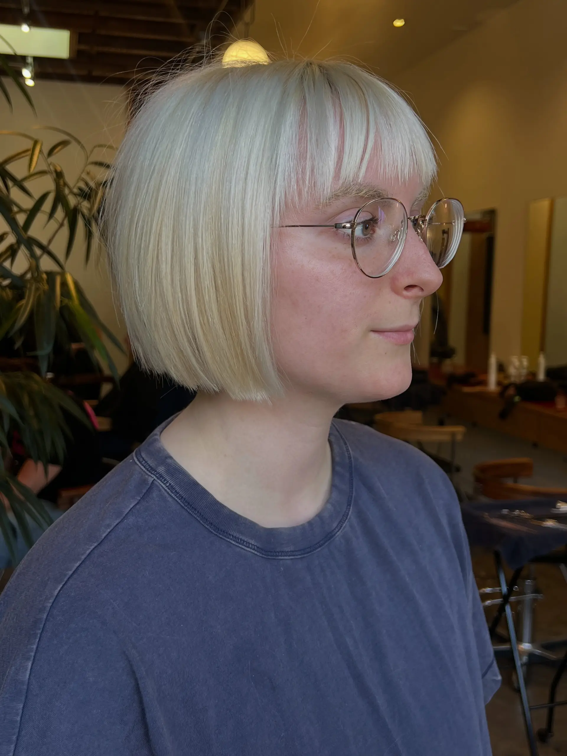 A sleek, chin-length platinum blonde bob featuring sharp blunt ends and soft fringe bangs. 1